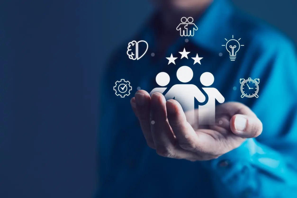 A businessman holding icons representing teamwork, customer satisfaction and human resources management
