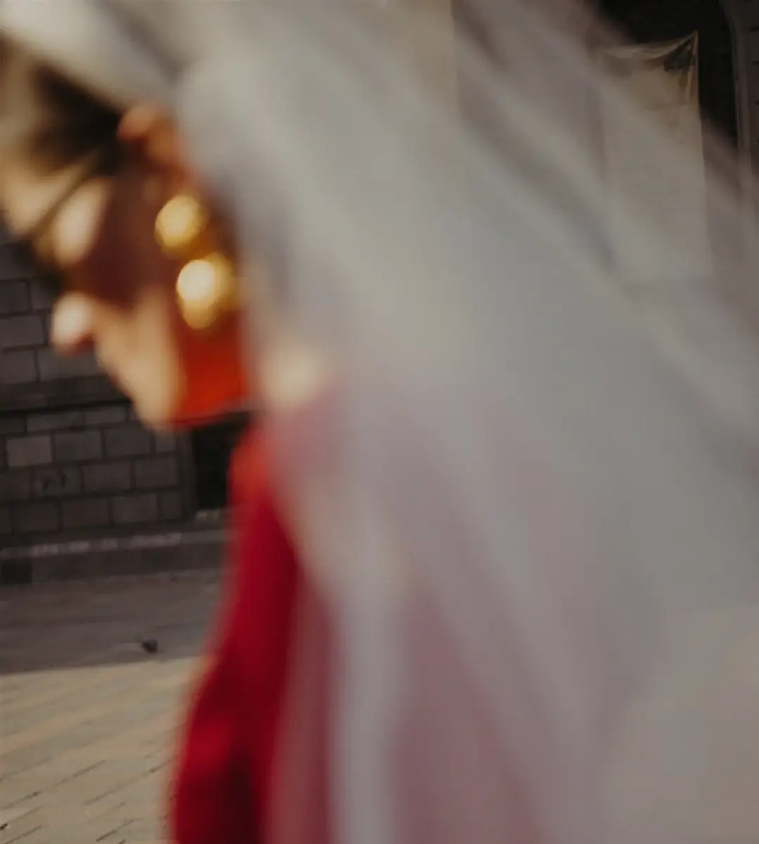 A photo of a bride with a white veil in a red dress, background image for a case study of a web design project for an elopement company VowsWellTraveled