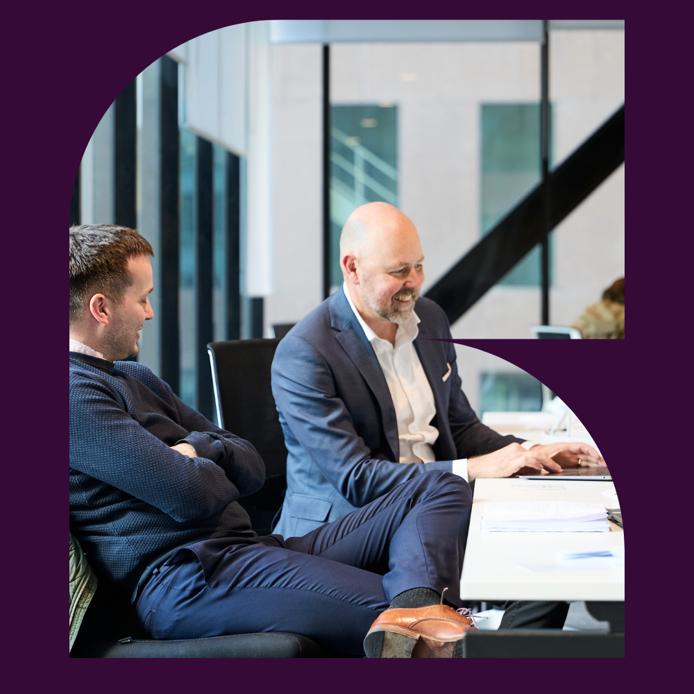 Two seisma employees collaborating during a meeting in a modern office workspace.
