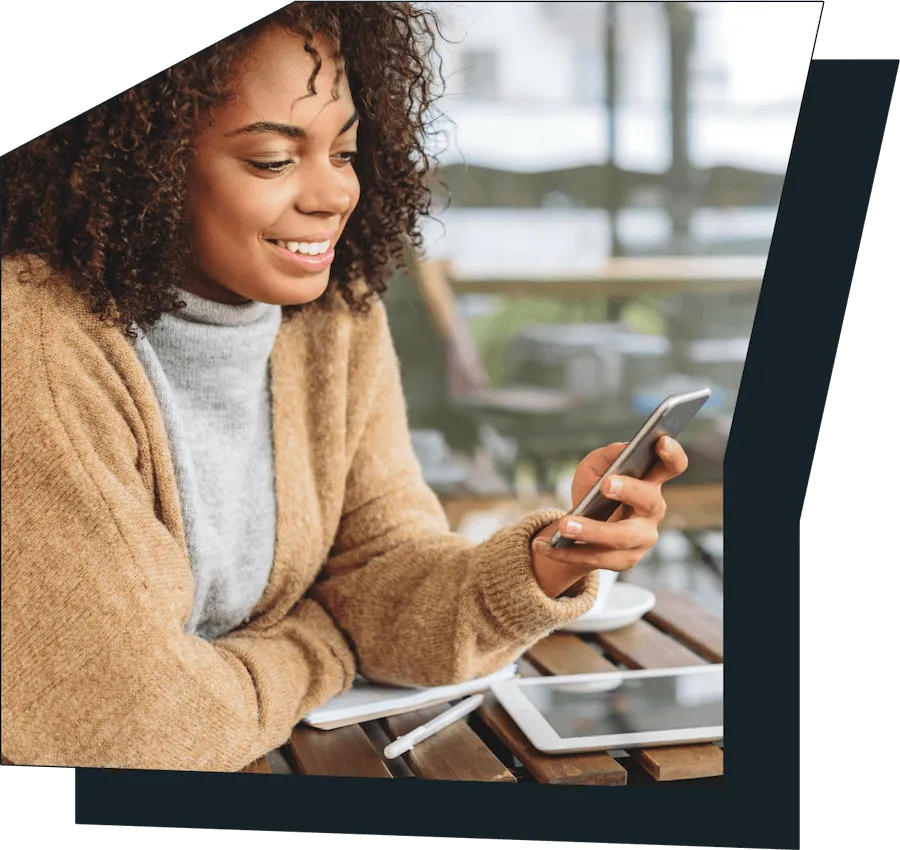 An image of a women on her phone, smiling.