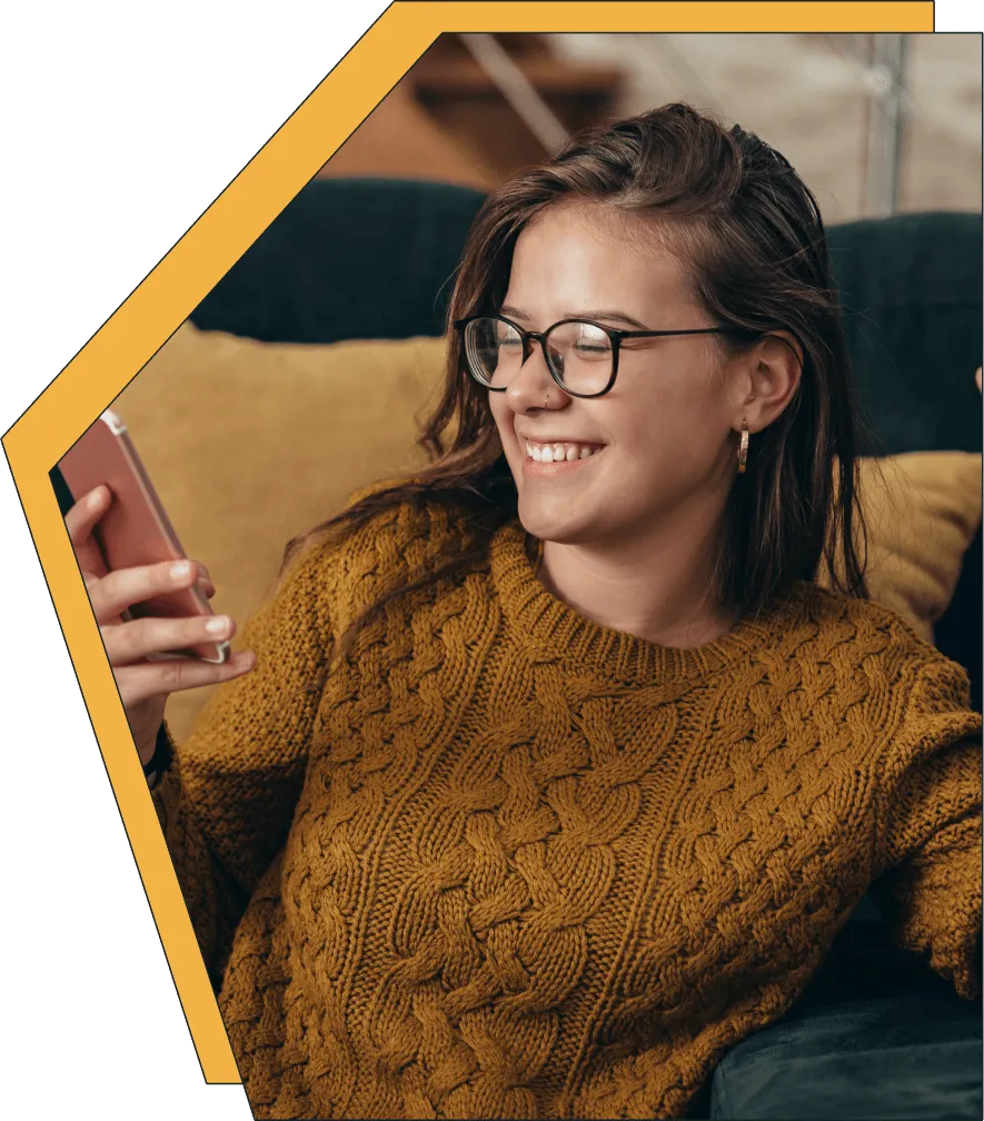 An image of a women on her phone, smiling.