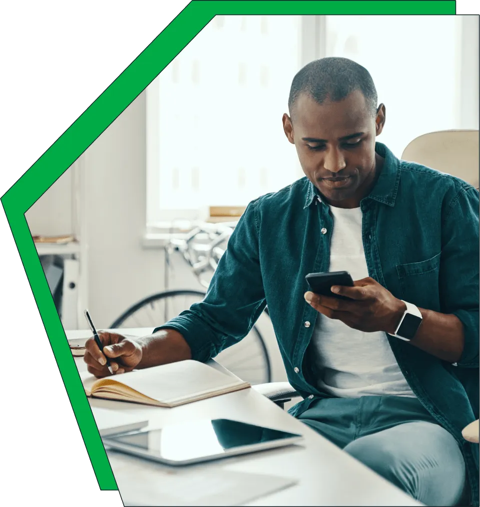 An image of a man on his phone, smiling.