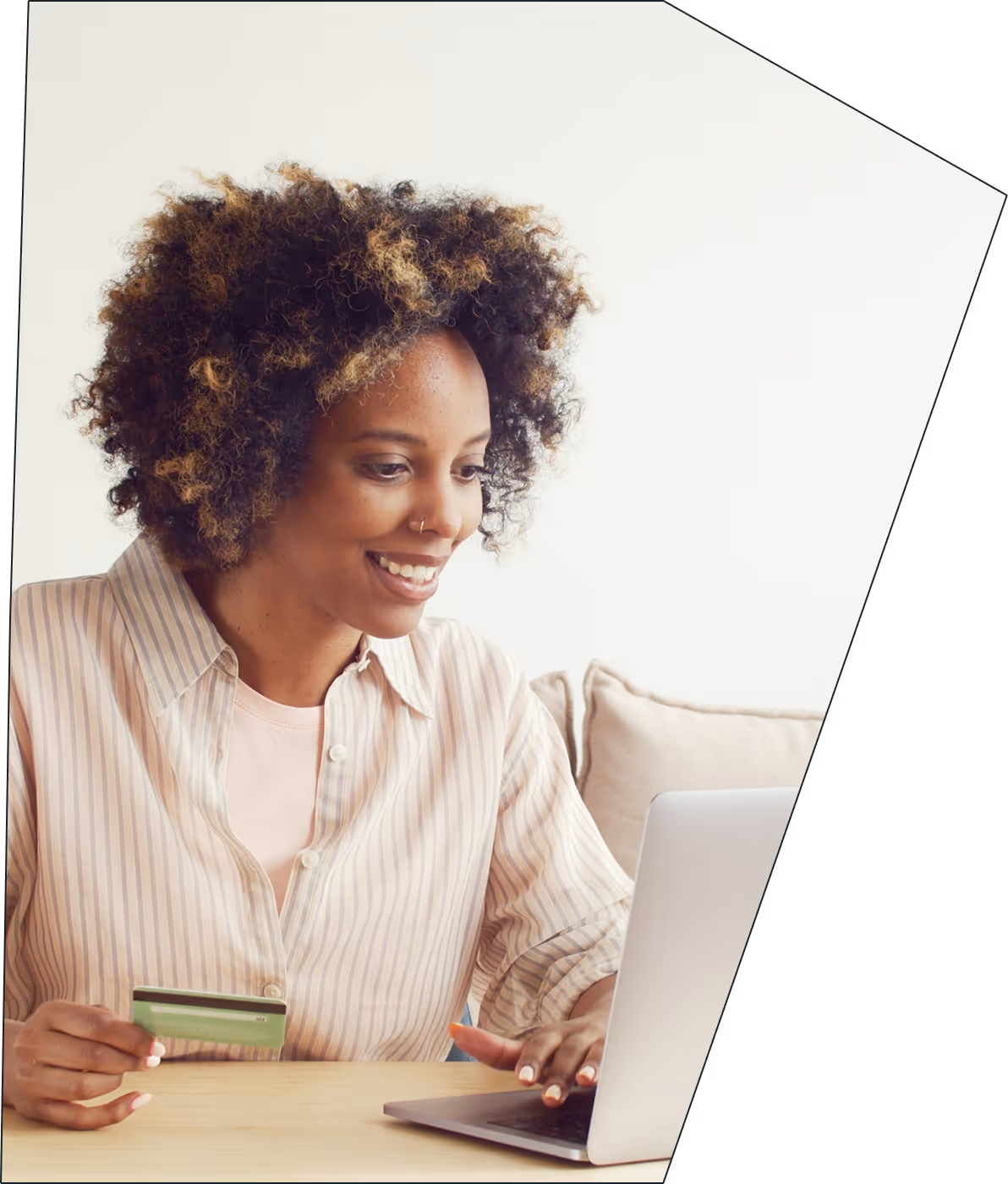 An image of a woman on her laptop, holding a credit card.