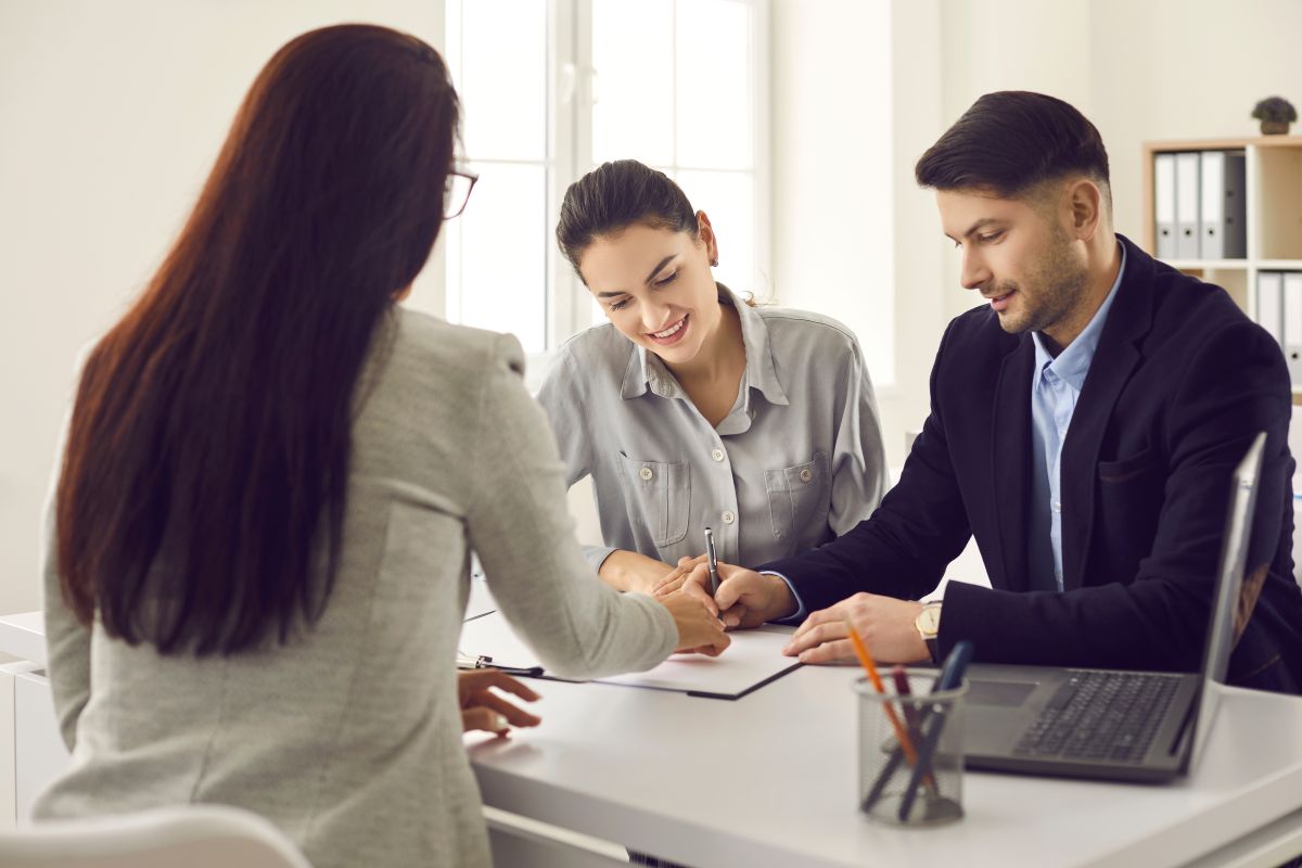 A picture of Clients signing paper documents at broker office