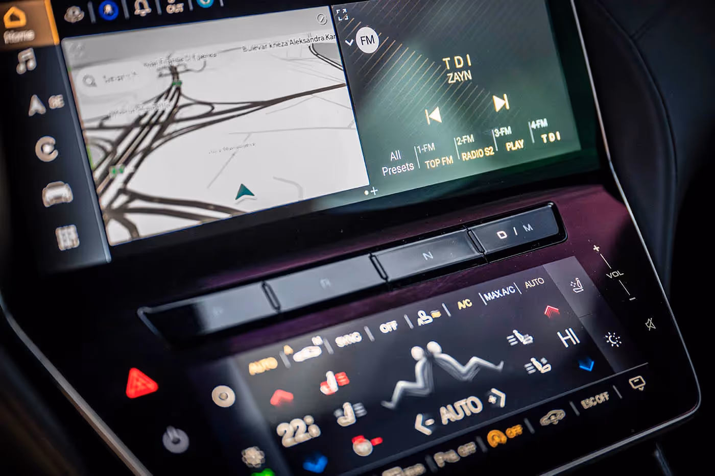 Gornji ekran nešto sporije reaguje na dodir. Između njega i donjeg ekrana smešteni su tasteri za komande automatskog ZF menjača sa osam stepeni prenosa