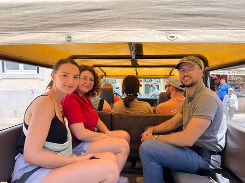 Participants assis lors d’une conférence ou table ronde dans un espace chaleureux aux poutres en bois. Un homme au centre prend la parole, les autres écoutent attentivement. Un projecteur est visible au premier plan, suggérant une présentation en cours.