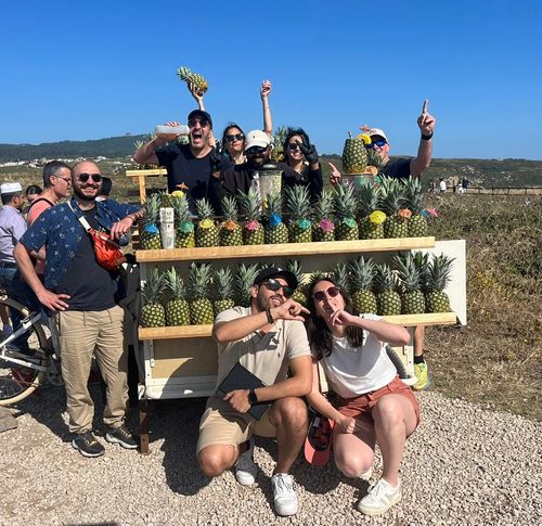Groupe de femmes réunies autour d’une grande table dans un espace cosy, en train de créer des compositions florales ou des décorations végétales avec des feuillages et des outils de bricolage. L’ambiance est chaleureuse et collaborative.