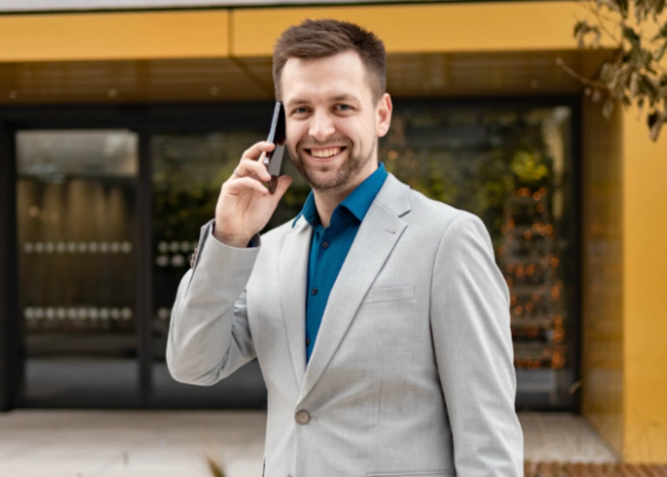 Zdenek Lehký, stojící před budovou kanceláři, právě telefonuje.