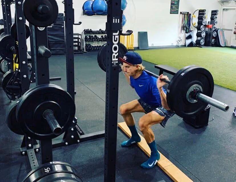 Man wearing blue shirt lifting weights