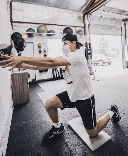 Man with white t-shirt and mask on his knees