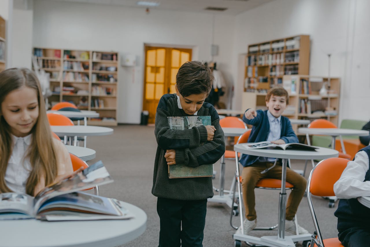 A boy being bullied by classmates in a school classroom setting