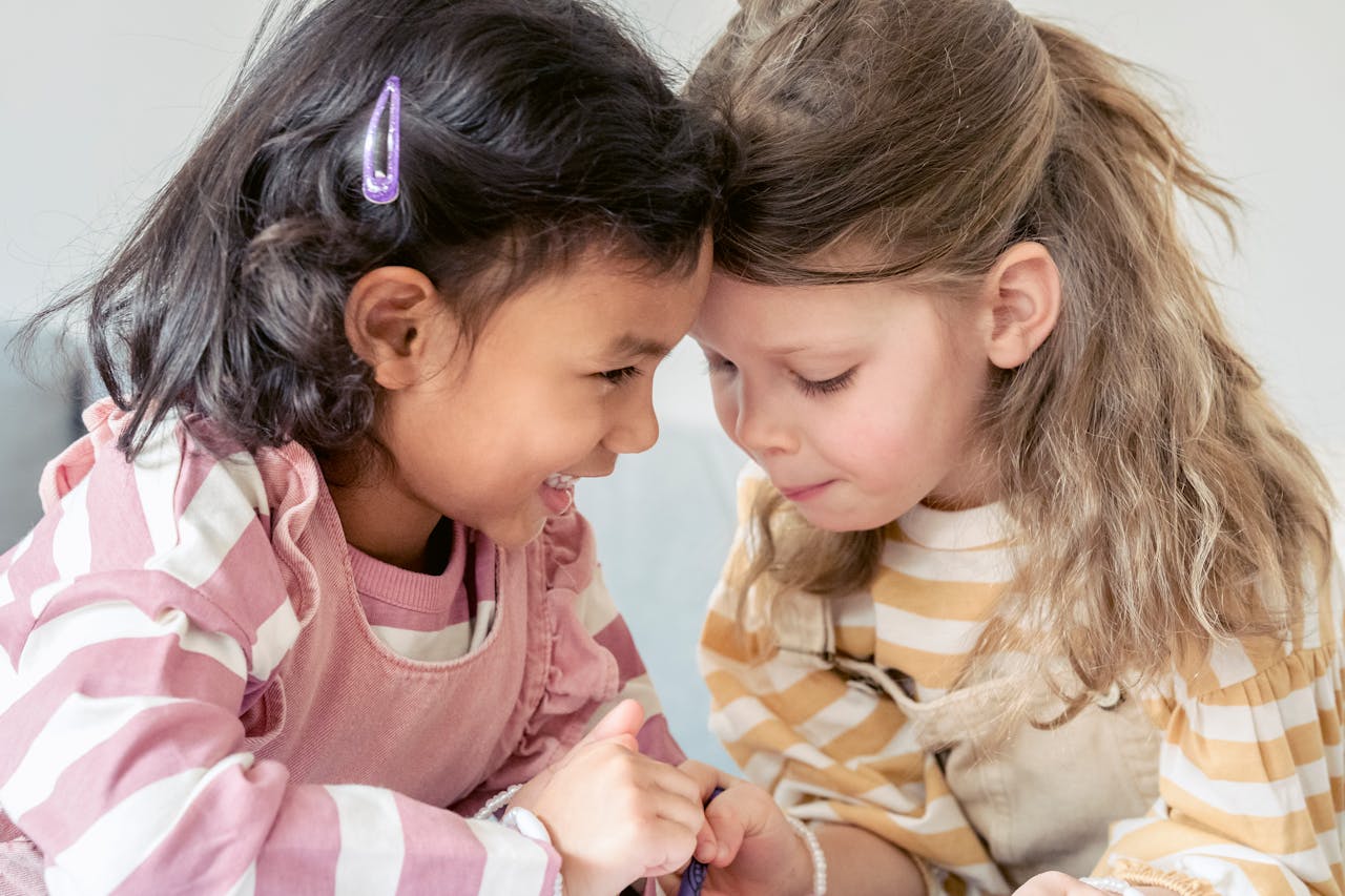 Close-up of two girls laughing and interacting, showcasing the bond of friendship and joy