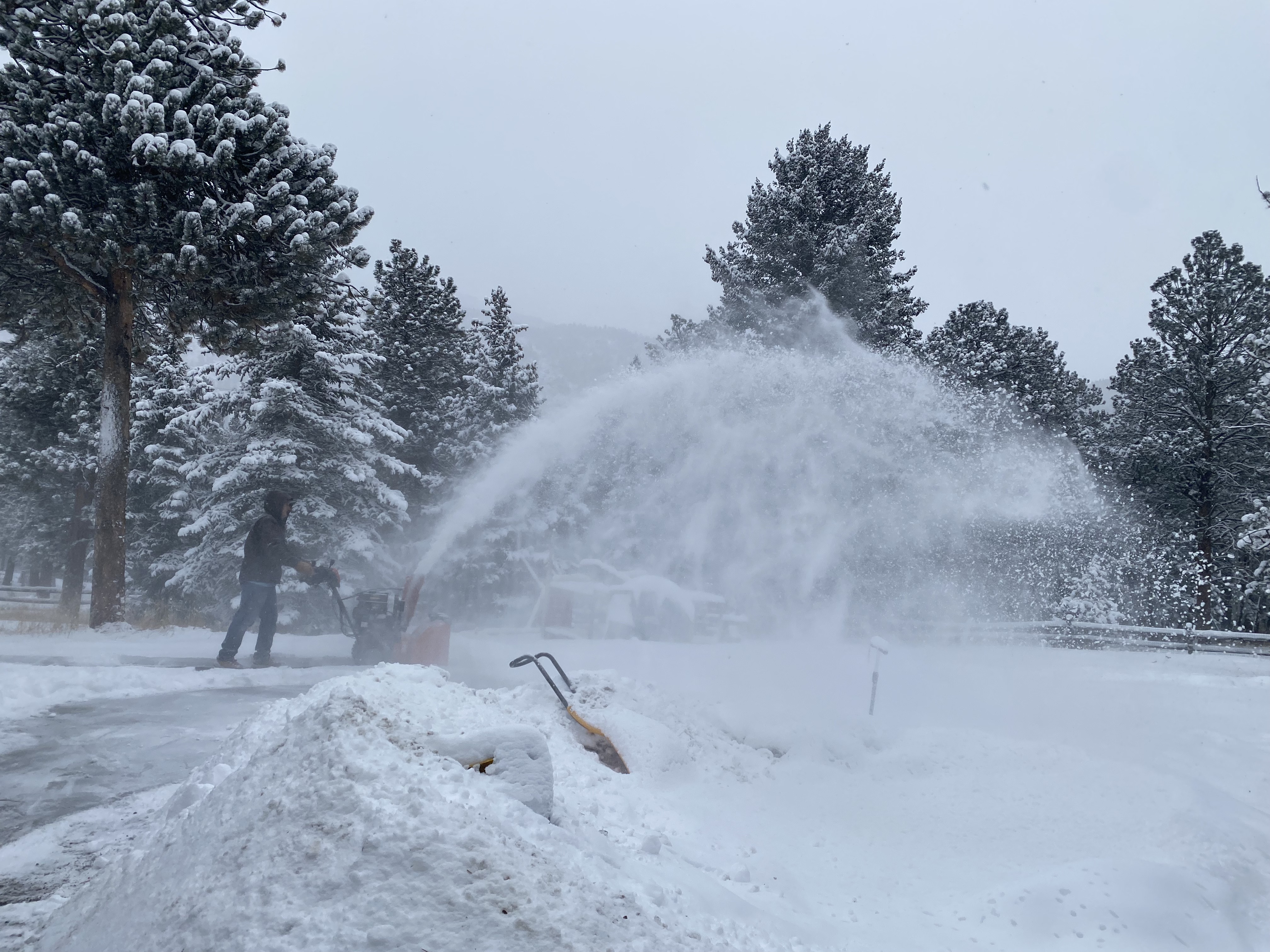Man blowing snow after a storm in Evergreen, Colorado