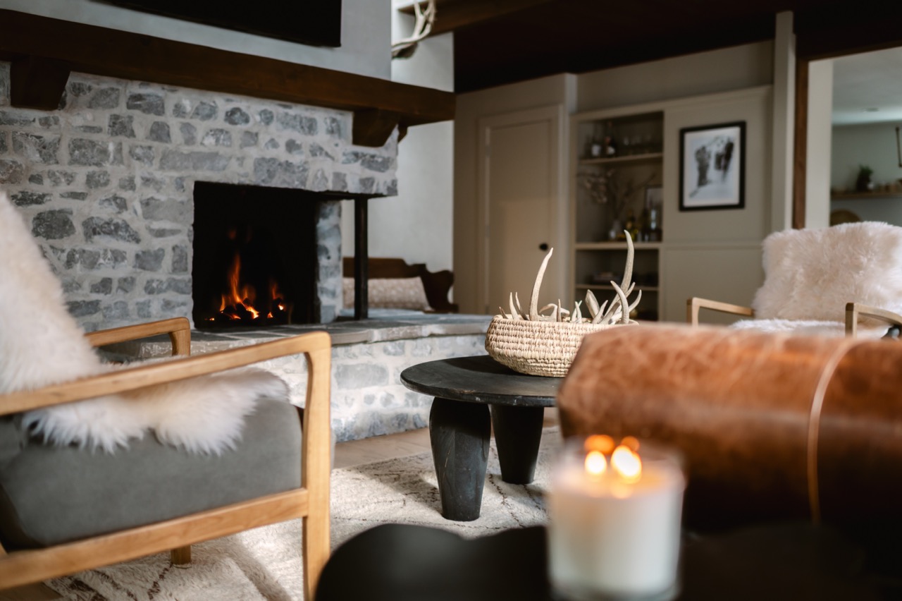 A cozy living room with a stone fireplace and mountain decor interior