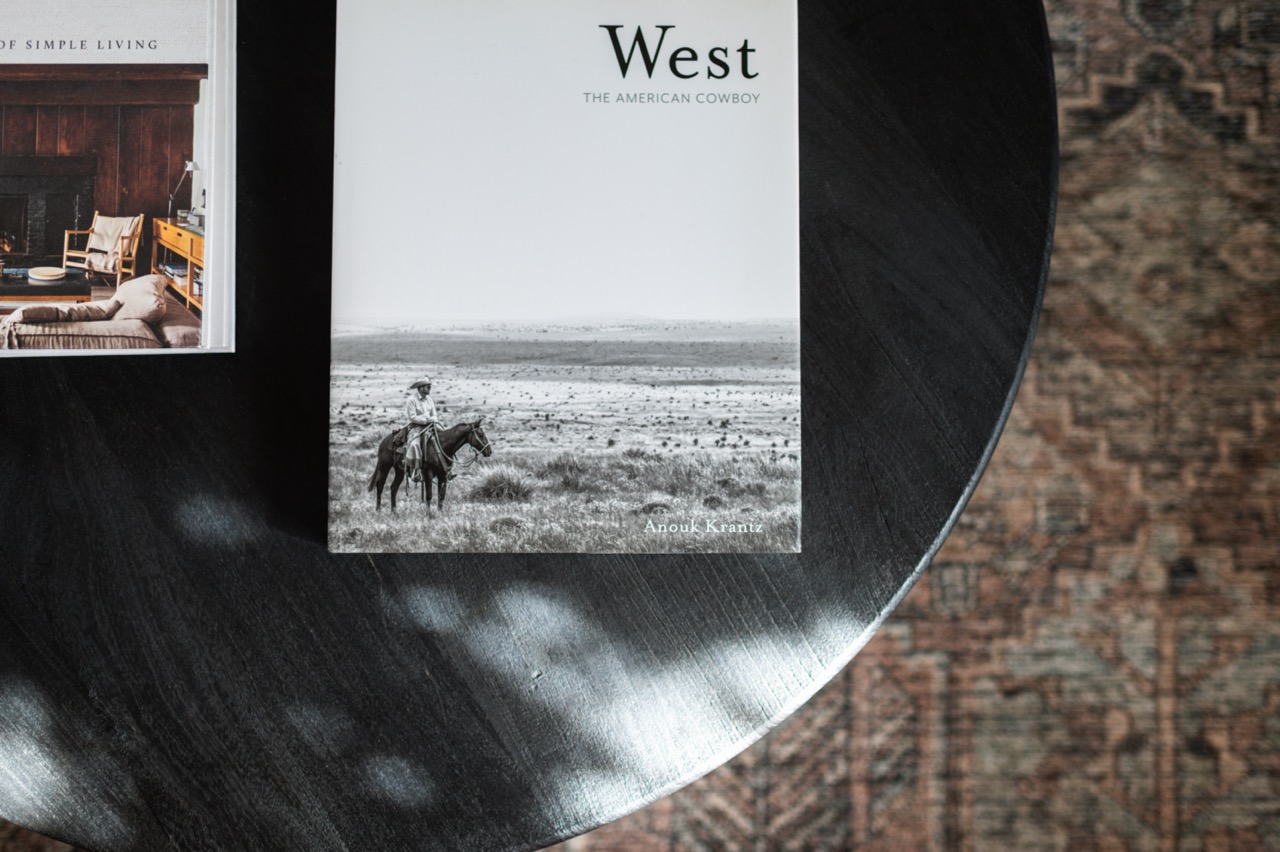 Top view of a black round table with two books, featuring a black and white photo of a cowboy on a horse on one book cover.
