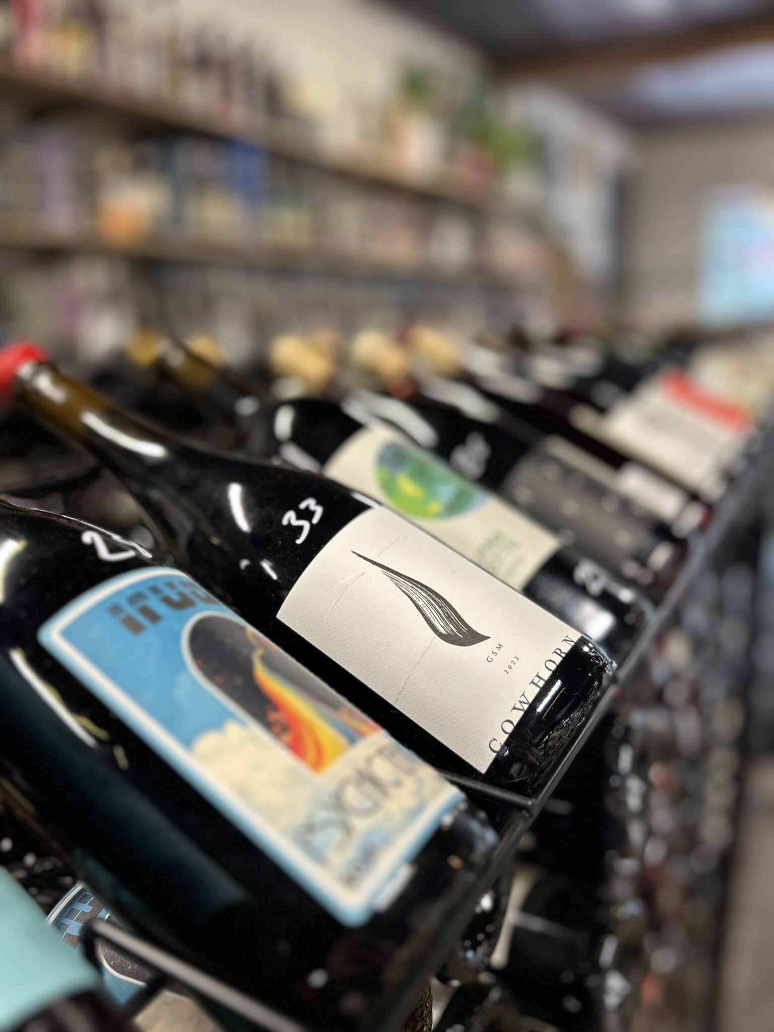 Close-up of wine bottles arranged on a rack at Piney Wine and Spirits.