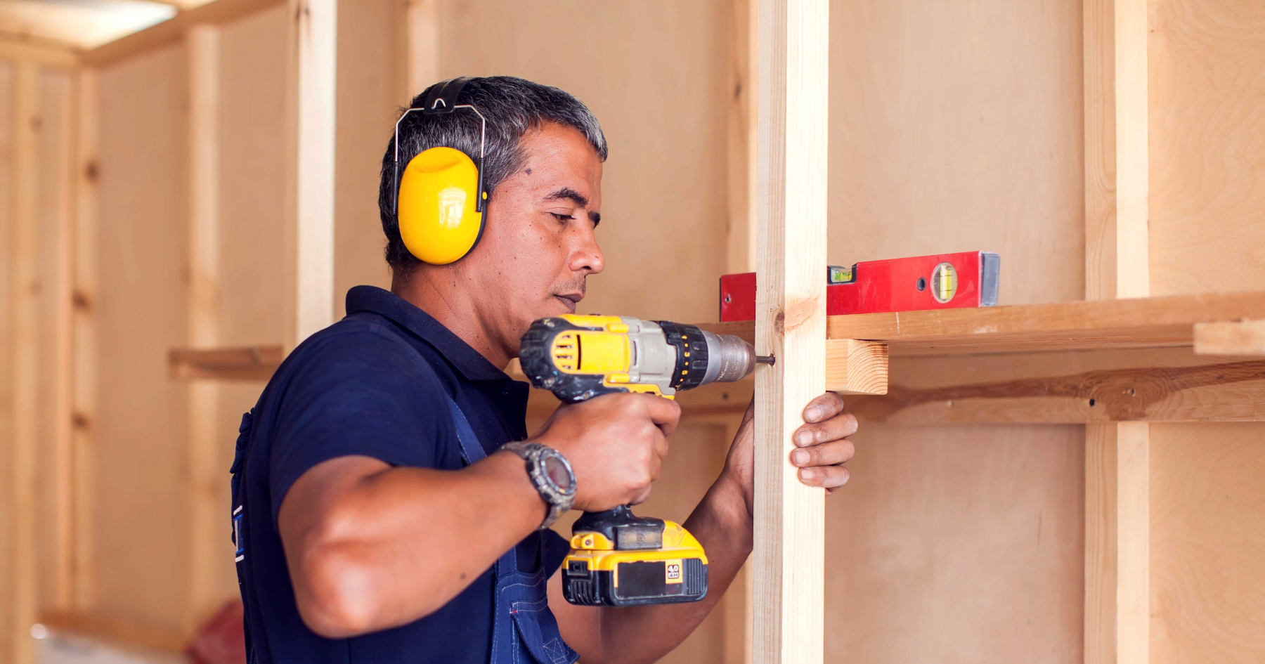 A worker using drill machine on wood