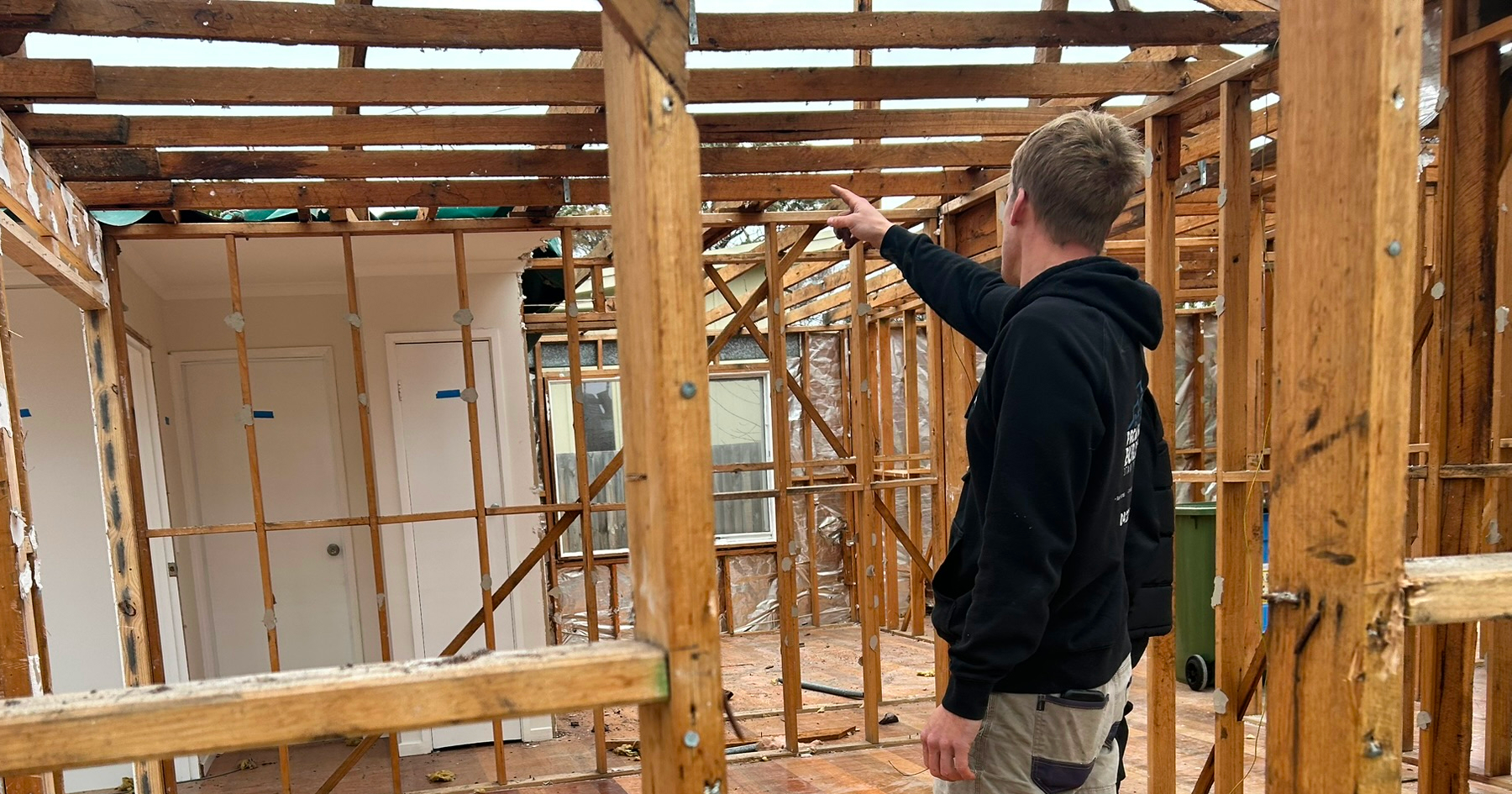 A construction worker pointing on a wood structure