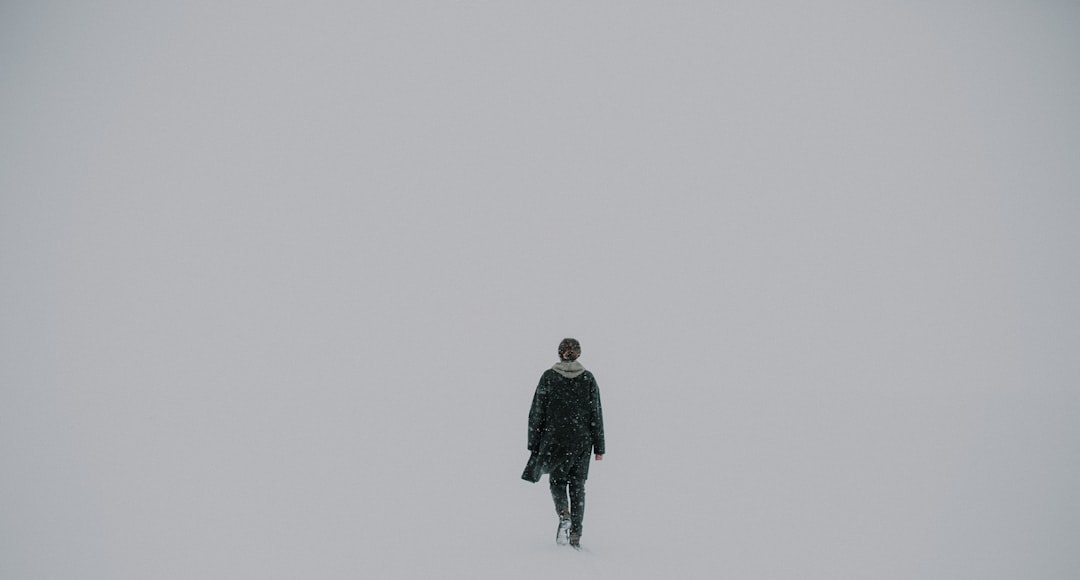 man walking alone on white surface
