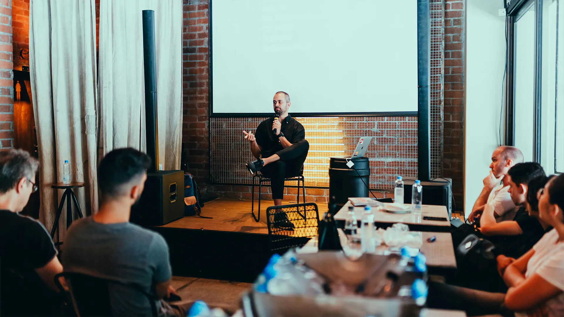 A man giving a talk to a small group of colleagues.