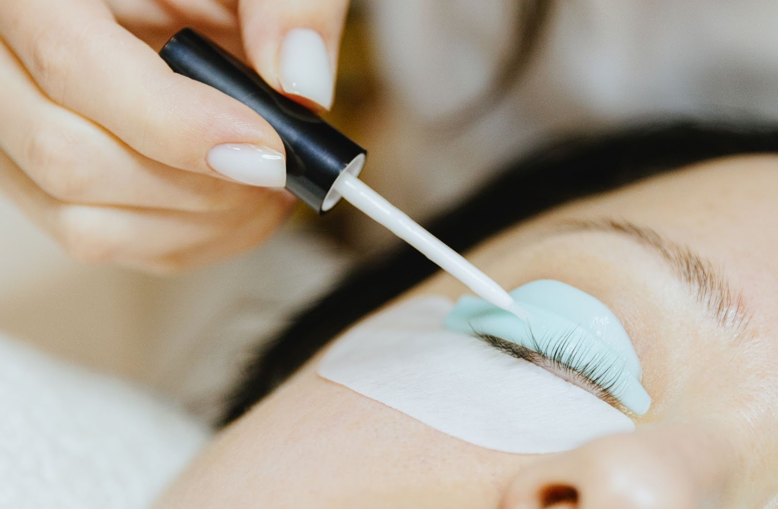 A close-up of eyelash lamination and tinting on a client’s lashes with precision.