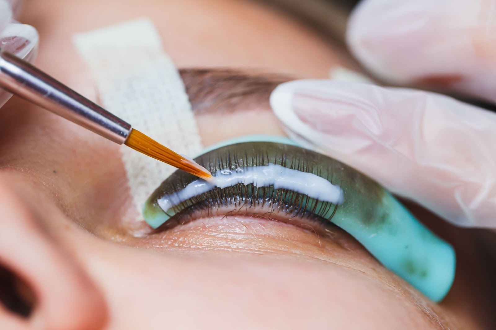 A close-up of a professional eyelash extension application by a certified lash technician.