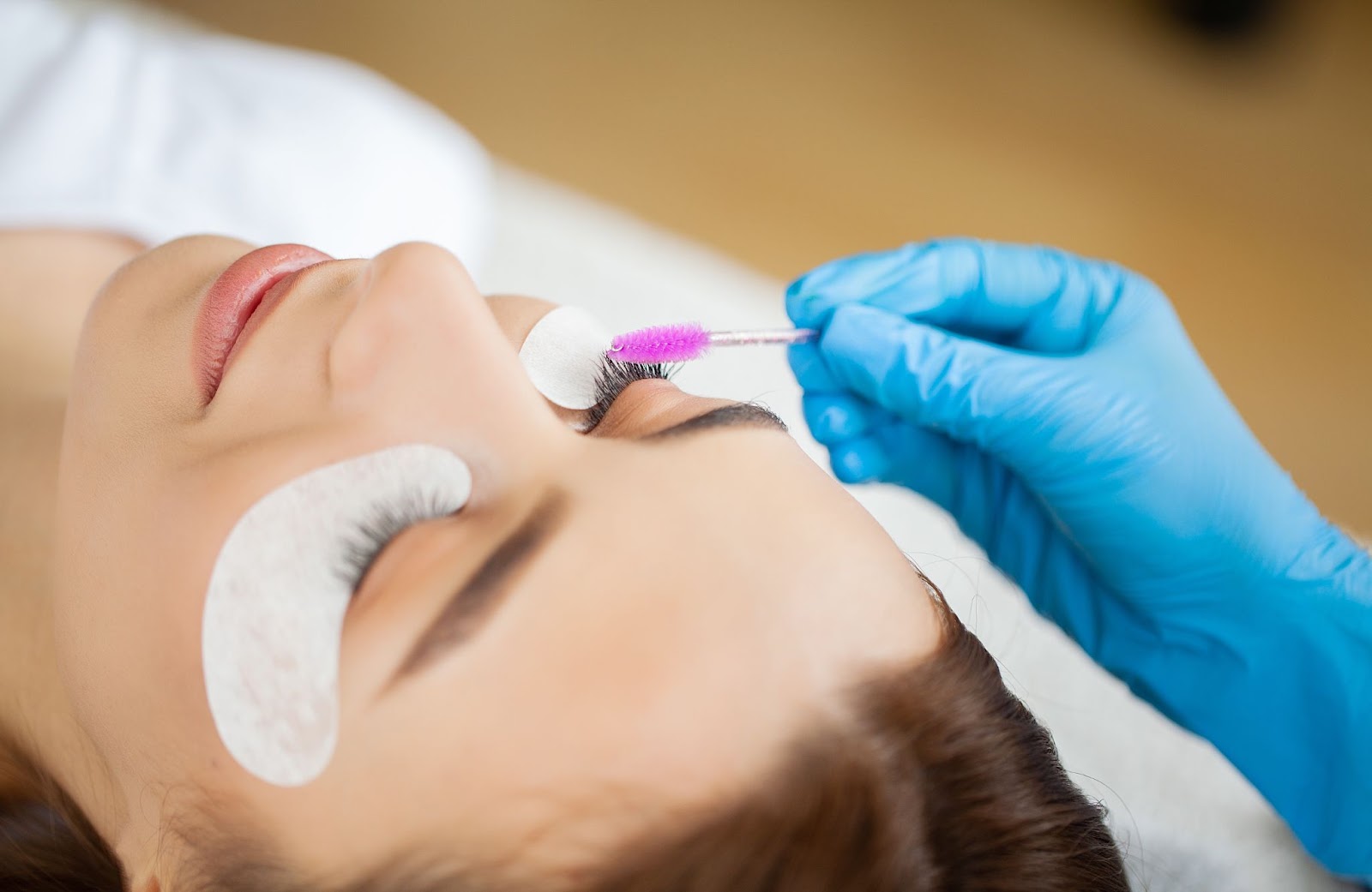 Detailed shot of a technician performing a lash lift treatment.