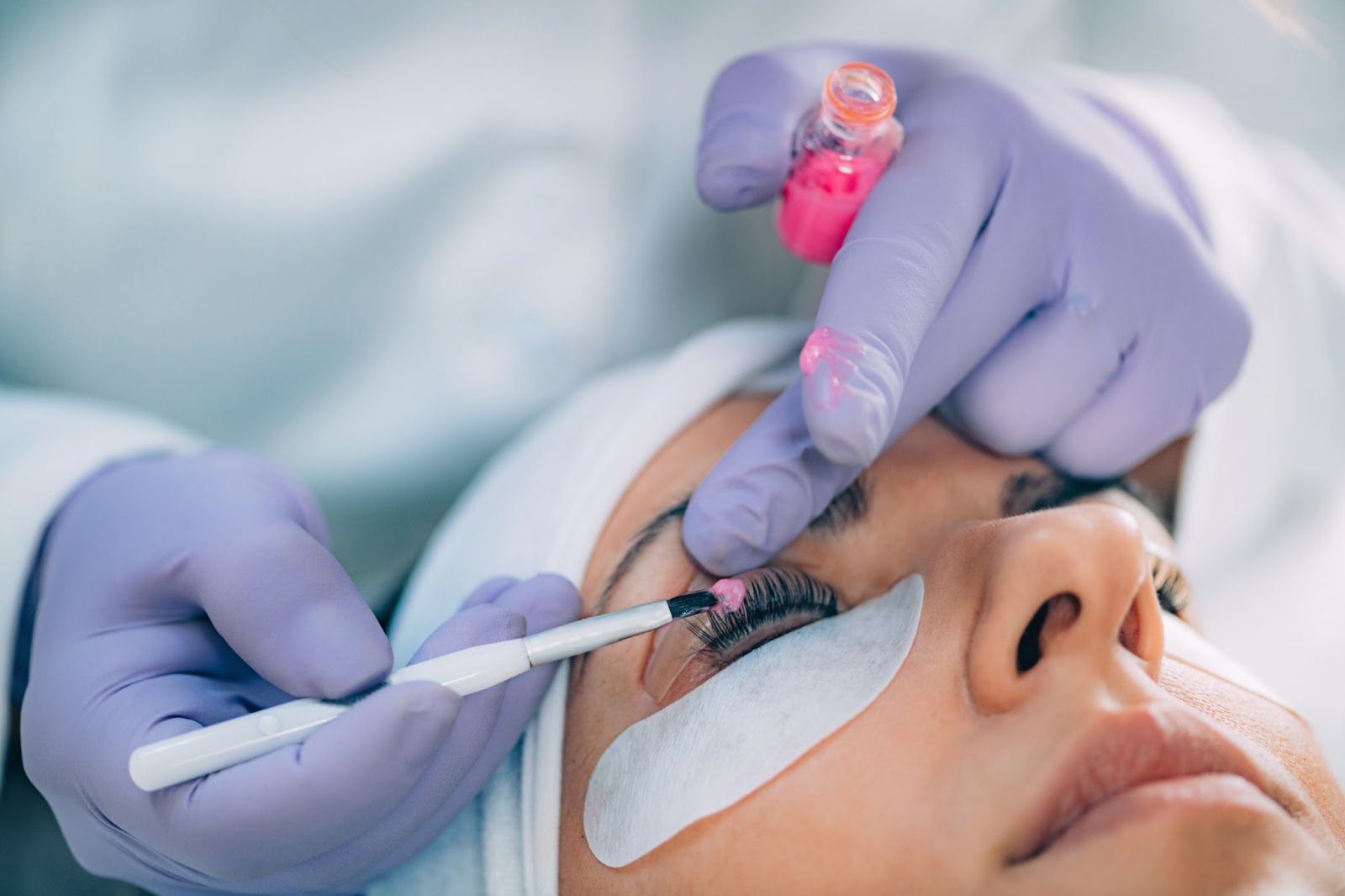 Under-eye view of professional eyelash lifting procedure in progress.
