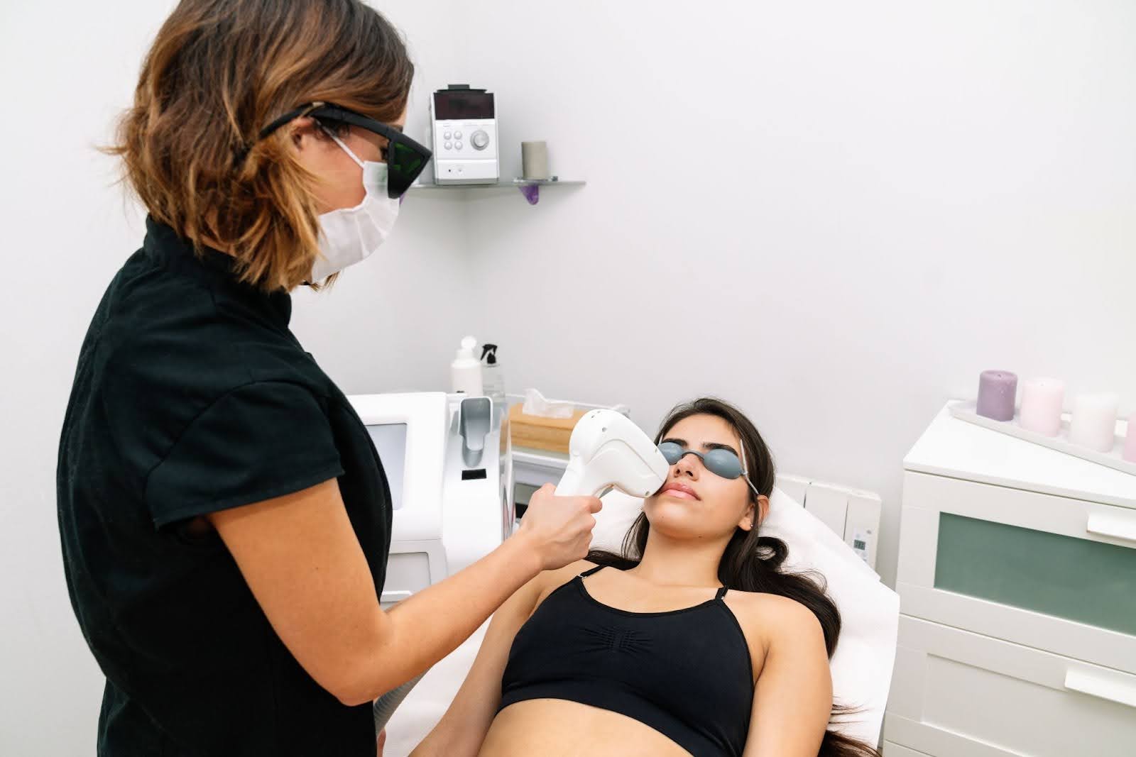 Professional laser hair removal procedure targeting hair on a woman's upper lip.