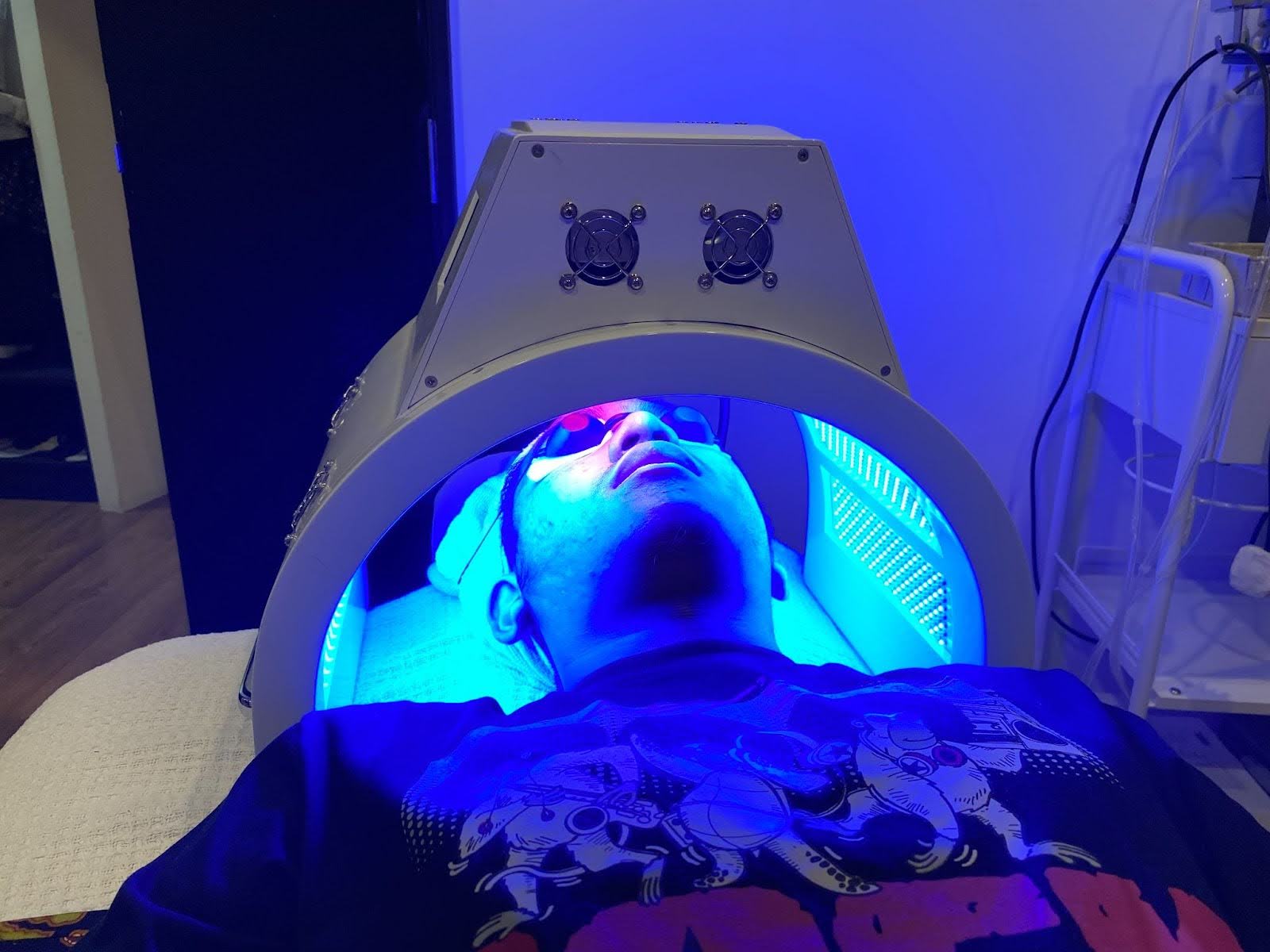 Blue LED light facial treatment targeting acne-causing bacteria on the skin.