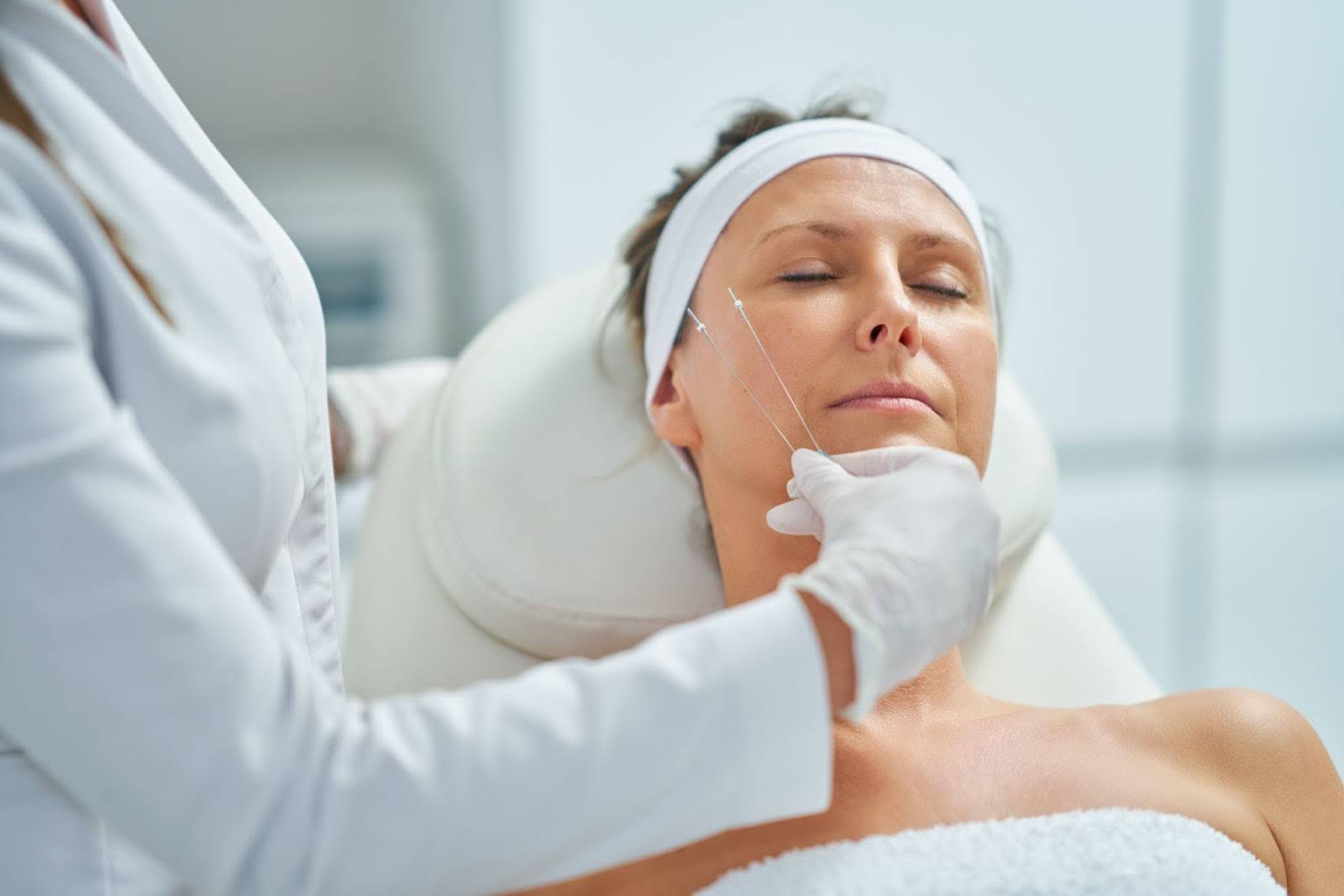 Aesthetic specialist measuring facial proportions as part of a medical cosmetology treatment for sagging skin.