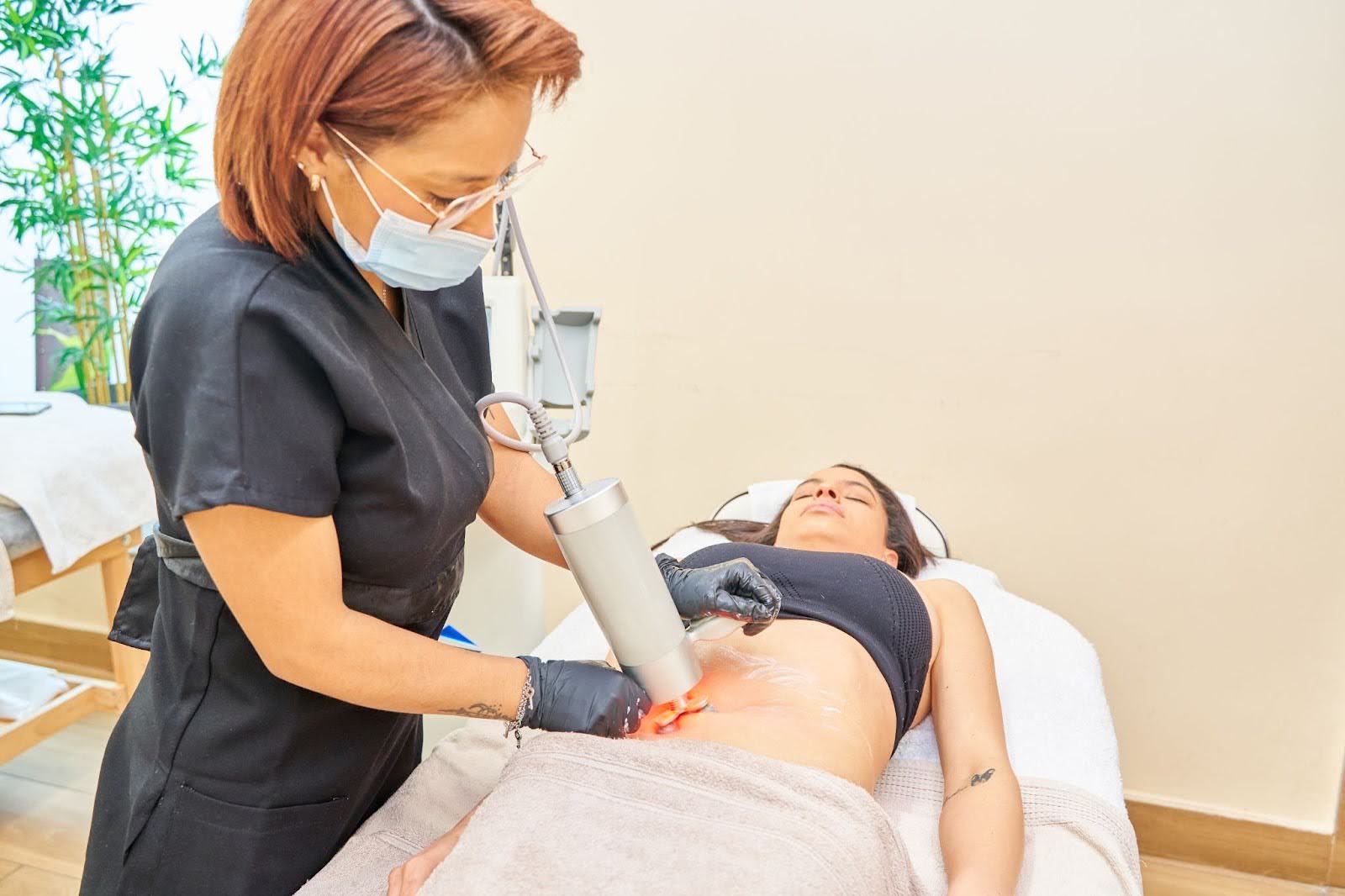 Abdominal radiofrequency treatment being performed on a woman at a professional med spa.