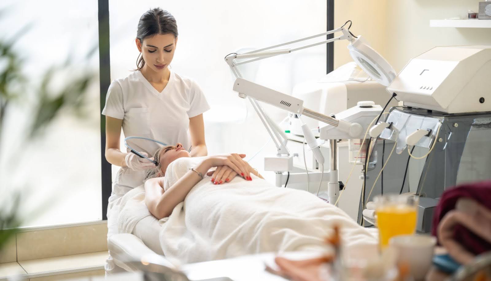 Licensed aesthetician performing a radiofrequency facial treatment to improve skin tone and firmness.