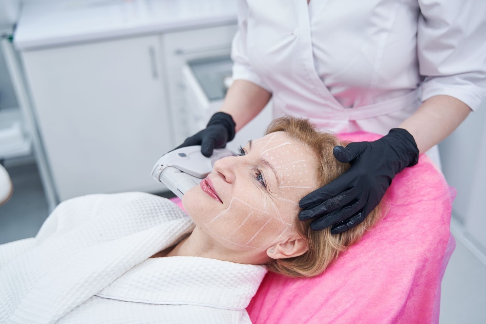 Woman undergoing treatment for facial skin tightening at a medical aesthetics clinic