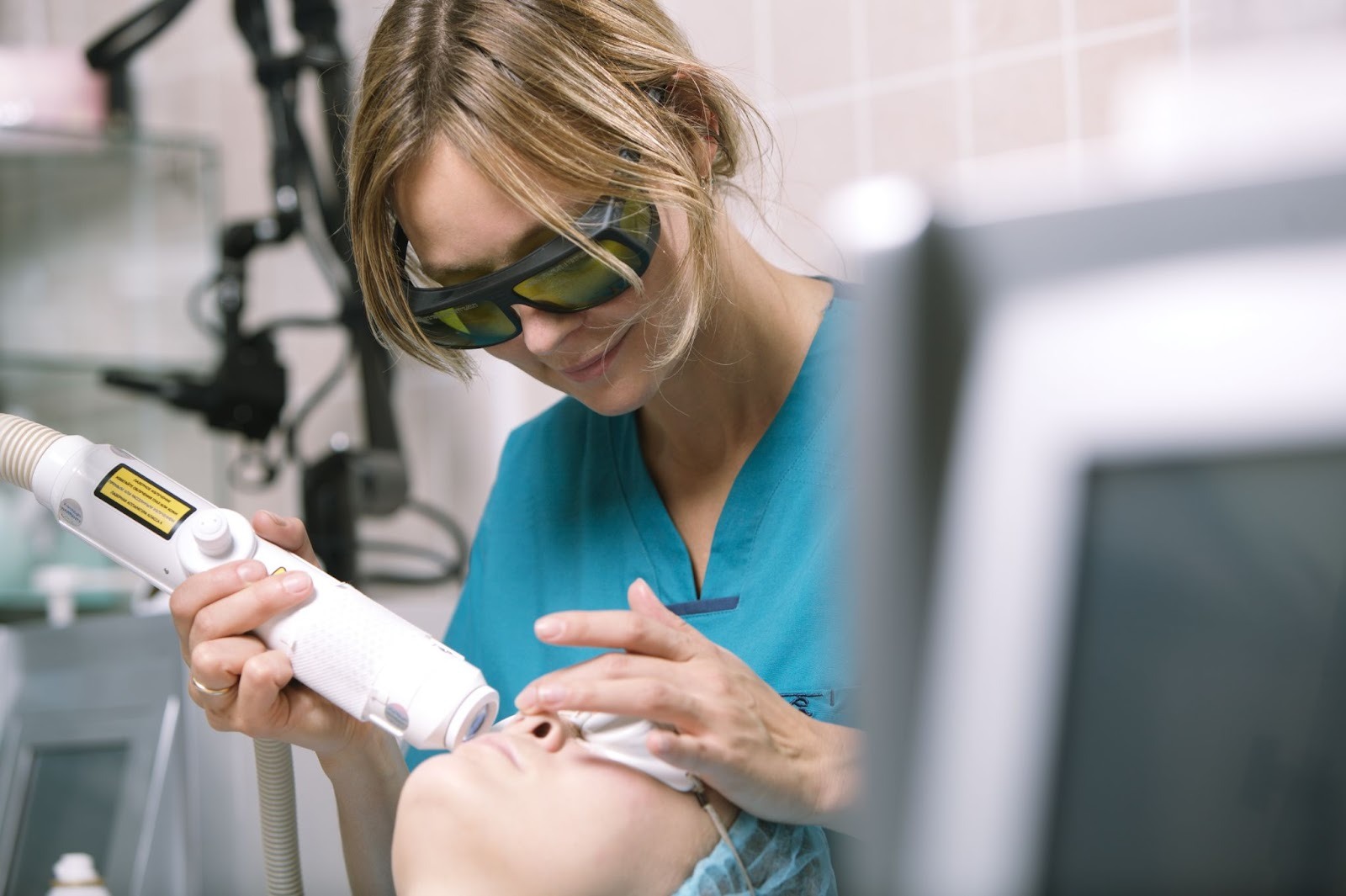 Woman receiving laser skin treatment for facial redness in a dermatology clinic