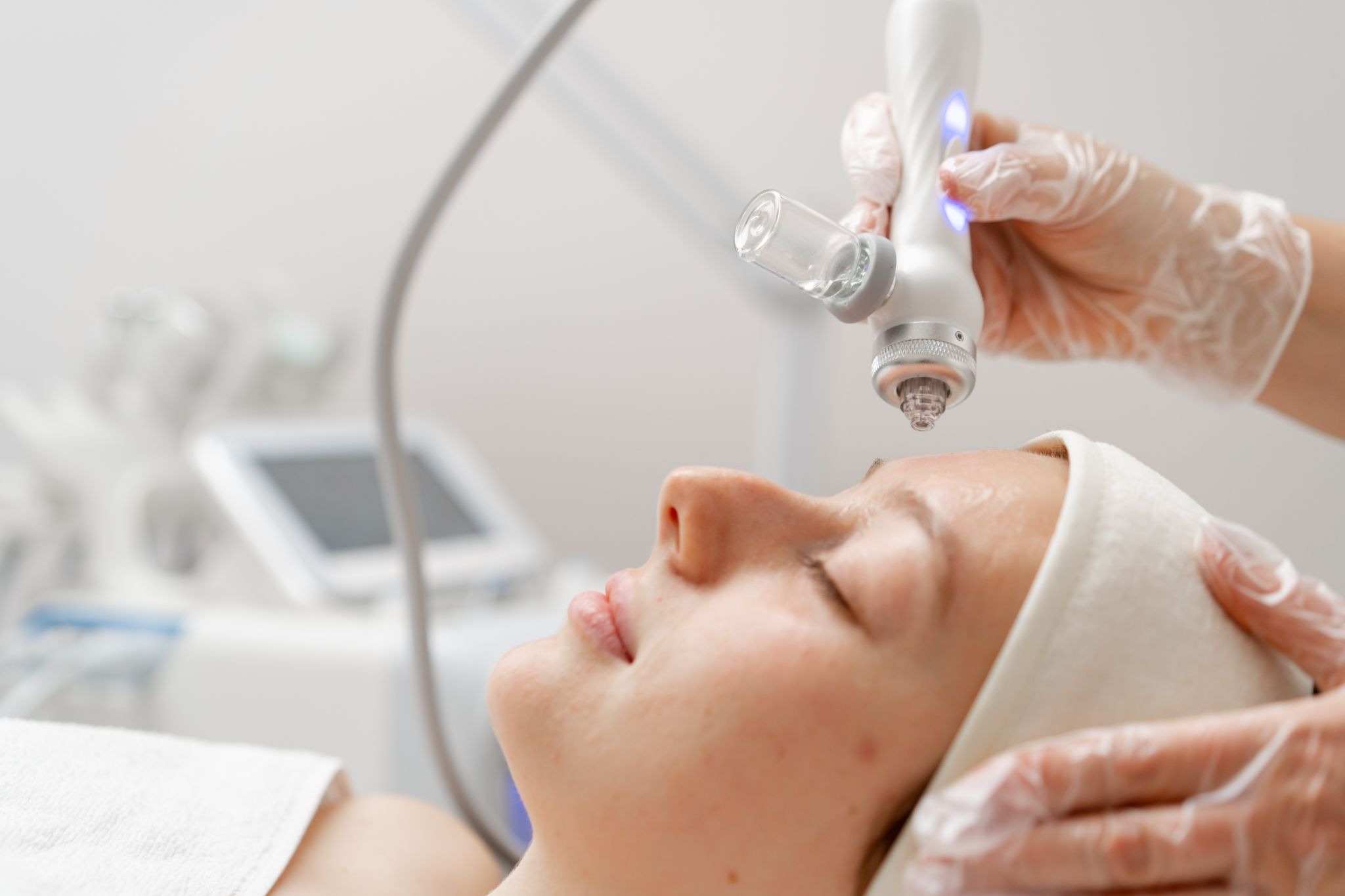 Aesthetic specialist cleansing a client's face to prepare the skin for oxygen therapy treatment