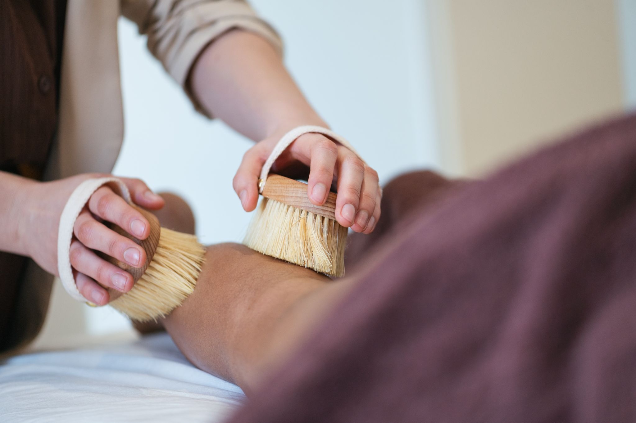 Dry brushing treatment at a wellness spa to support lymphatic drainage and circulation