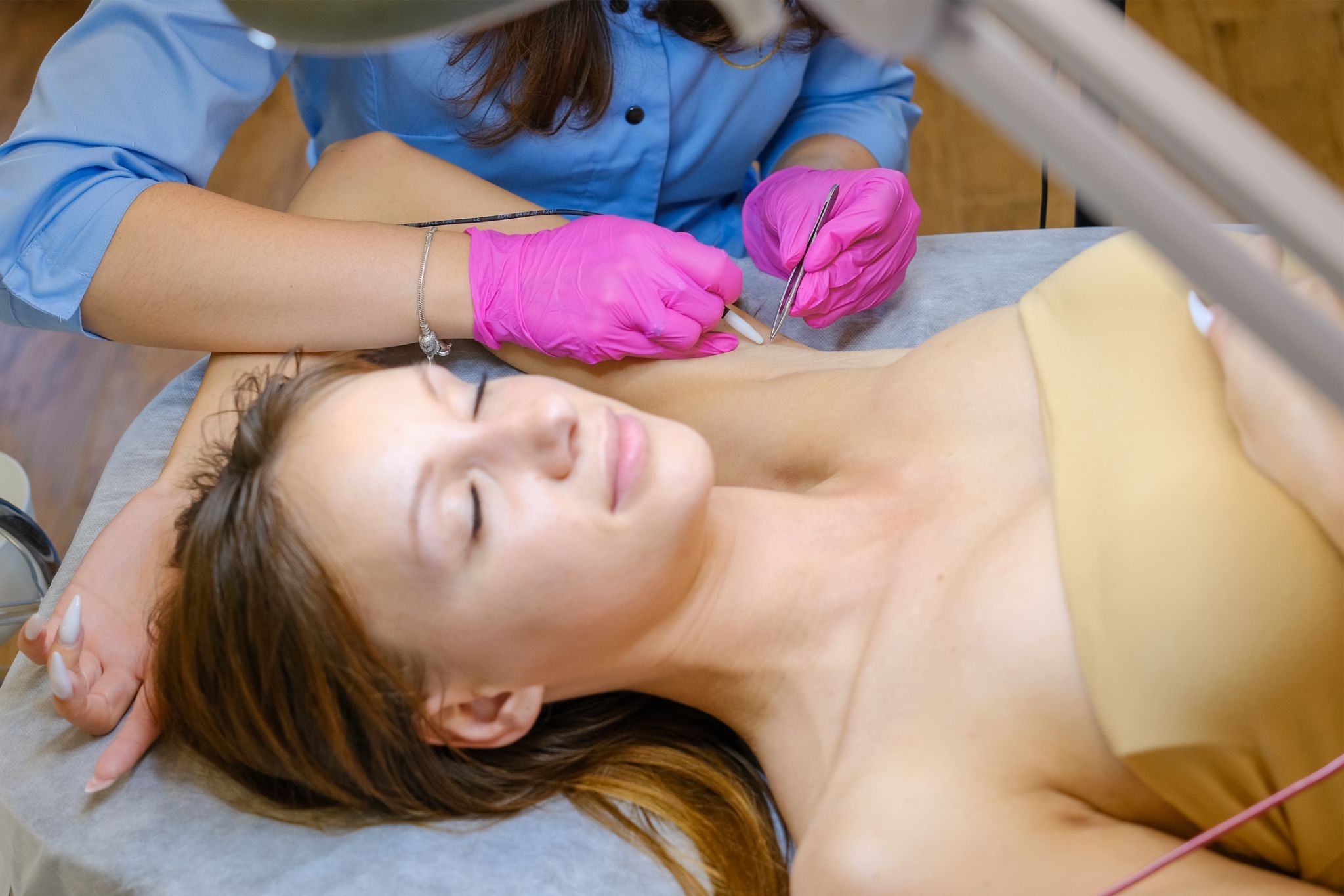 Woman receiving underarm electrolysis treatment in a clinic