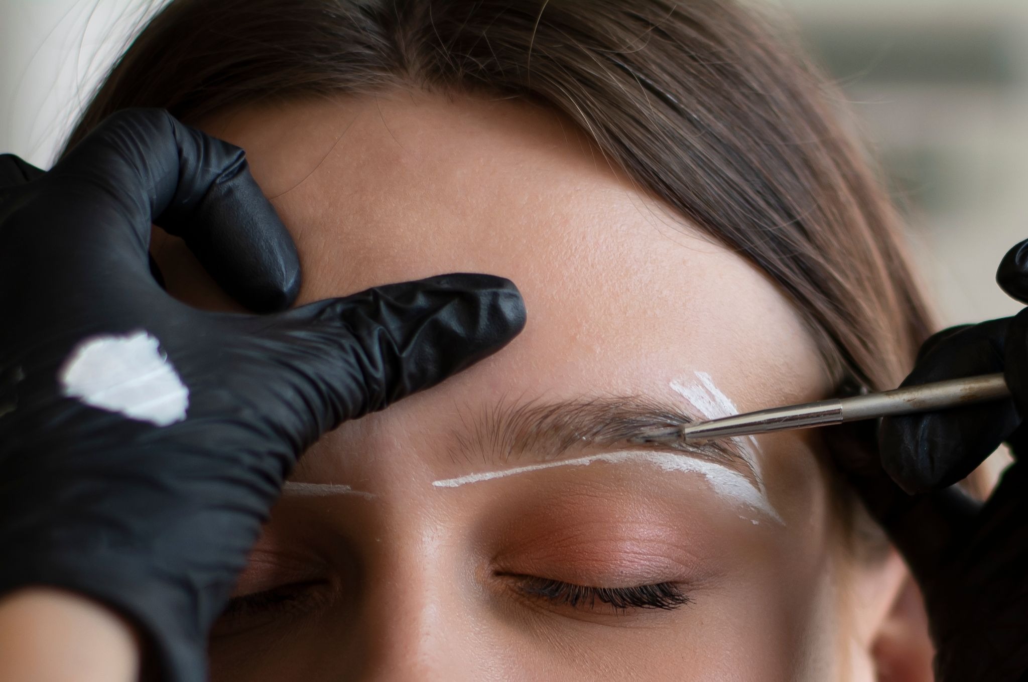 Eyebrow lamination with white mapping paste to define shape and create fuller, lifted brows