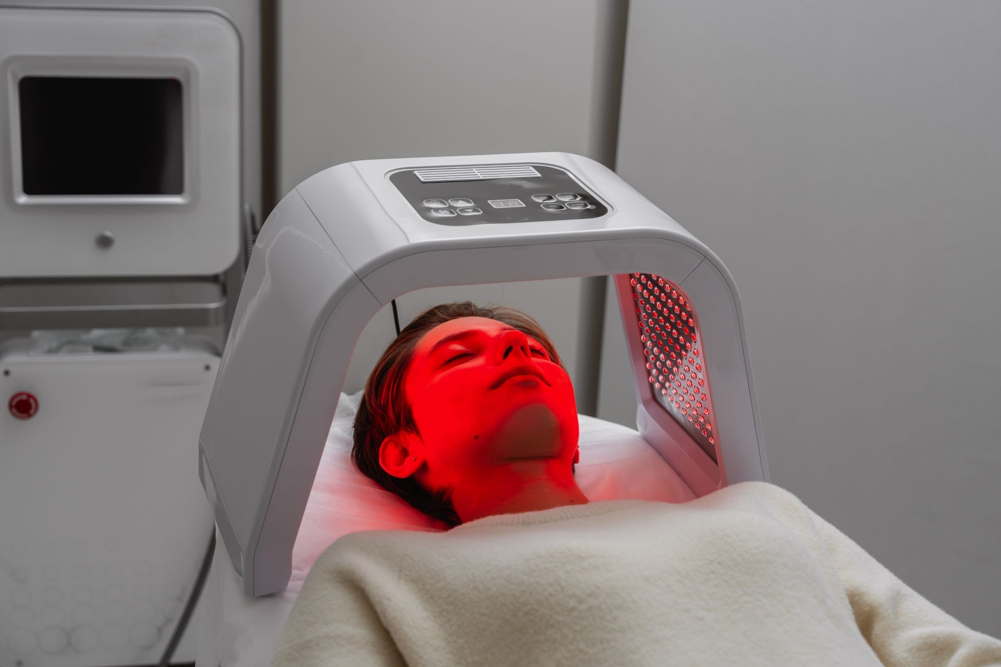 Client receiving red light therapy facial session for anti-aging and skin repair benefits