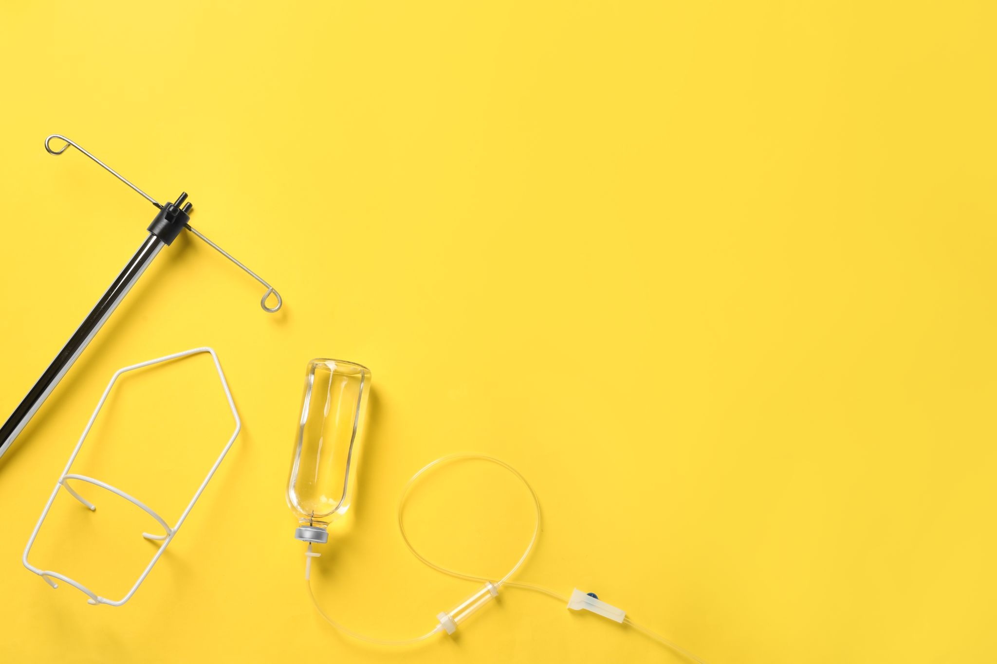 IV drip kit components arranged on a bright yellow surface