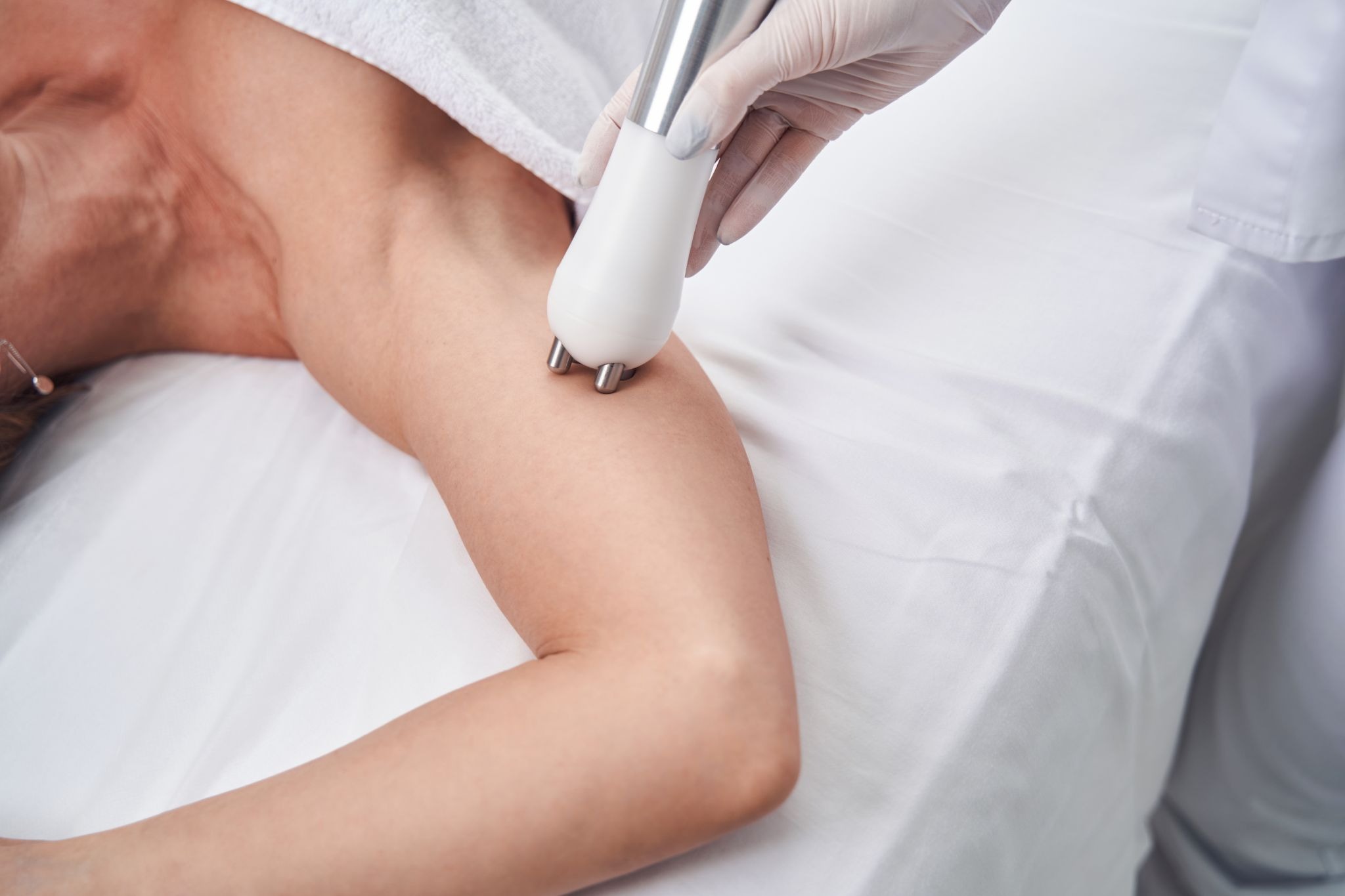 Partial view of a woman undergoing an aesthetic treatment to improve arm skin firmness‍