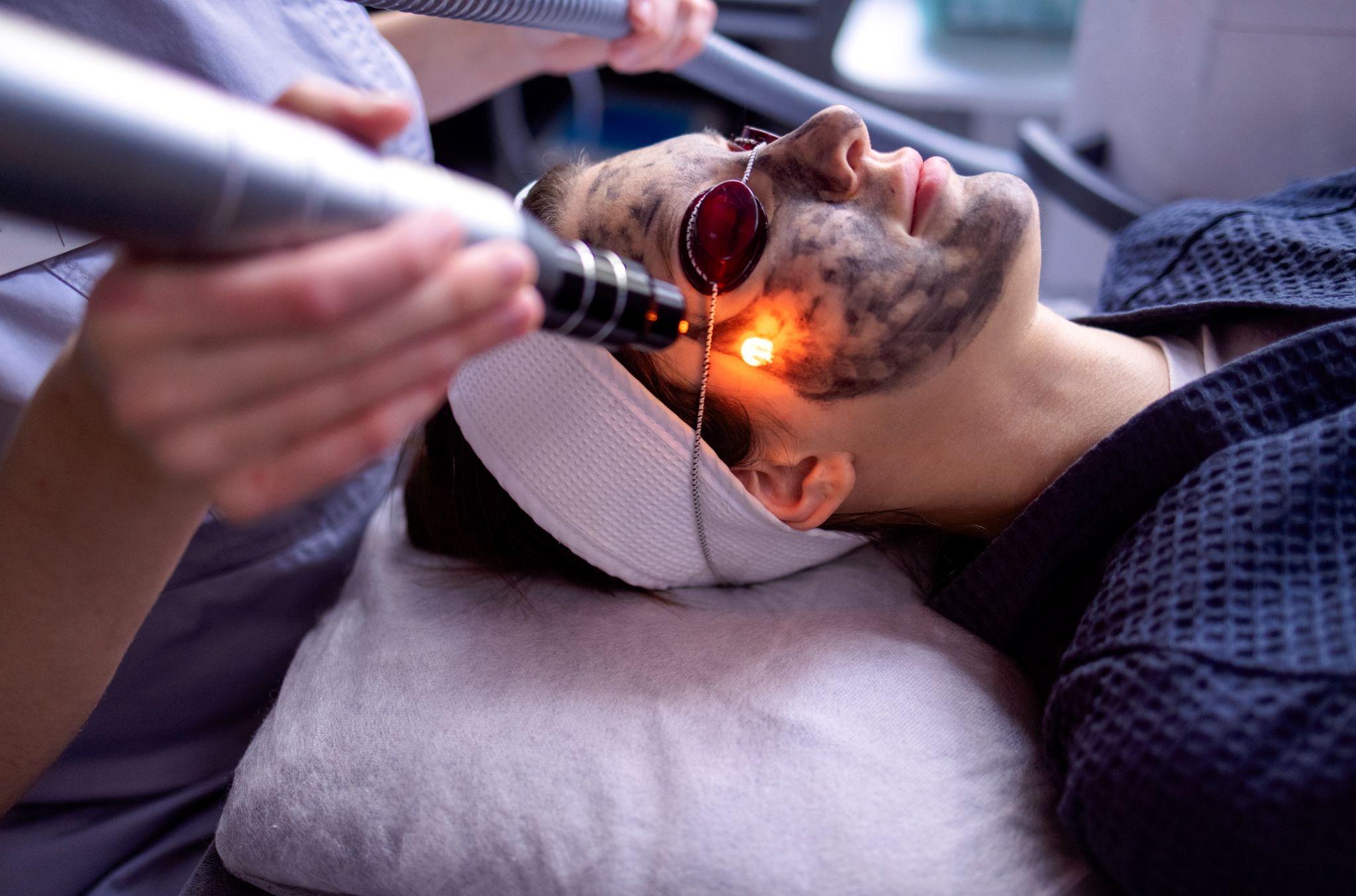 Woman receiving professional laser therapy to improve facial scar texture and tone