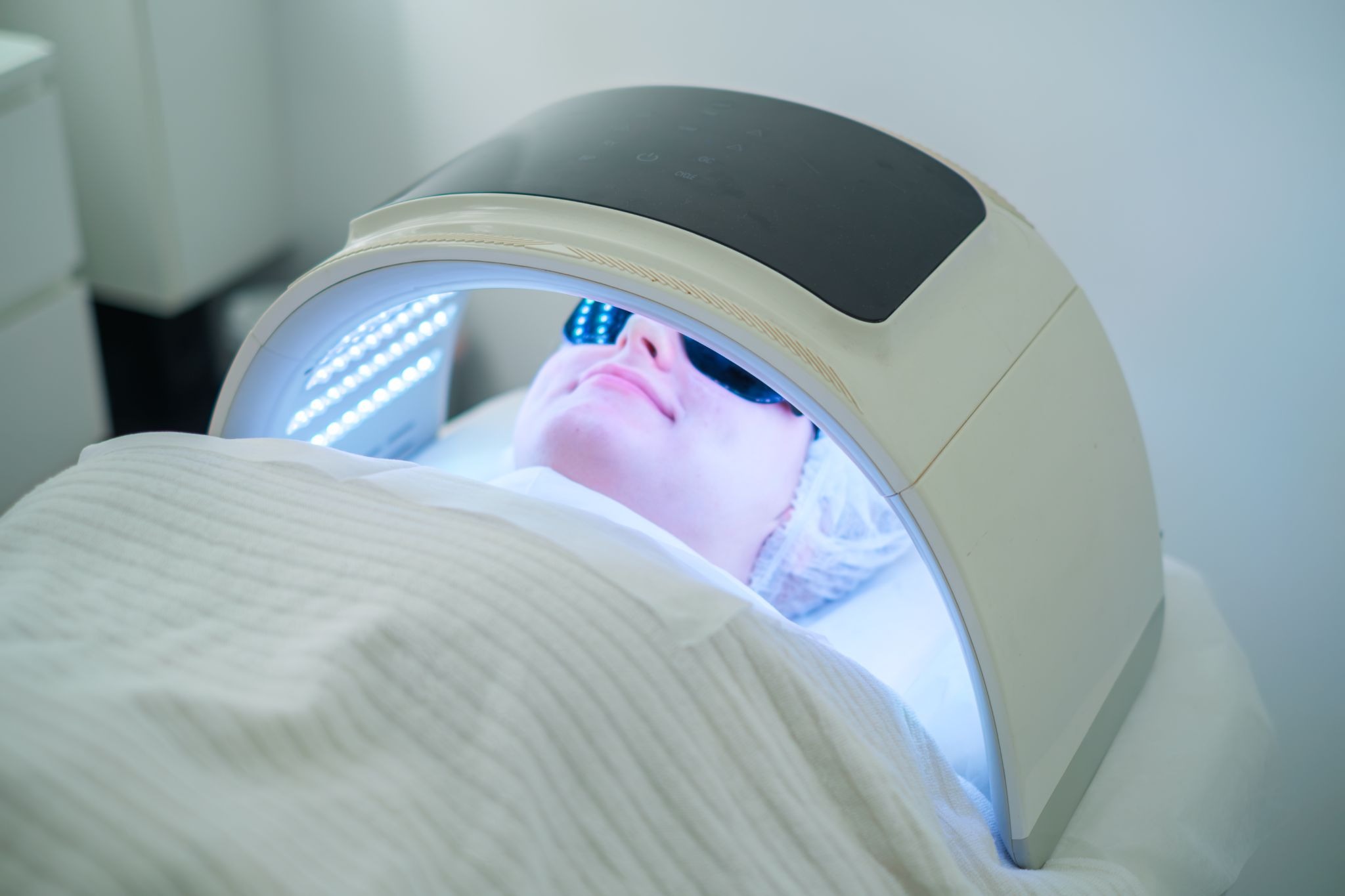 Female client undergoing LED light therapy for acne treatment at a med spa