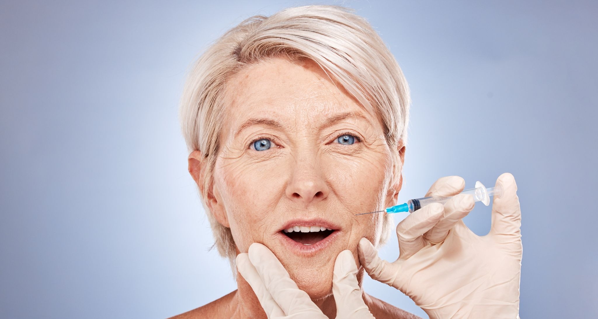 Mature woman receiving a dermal filler injection to reduce nasolabial folds