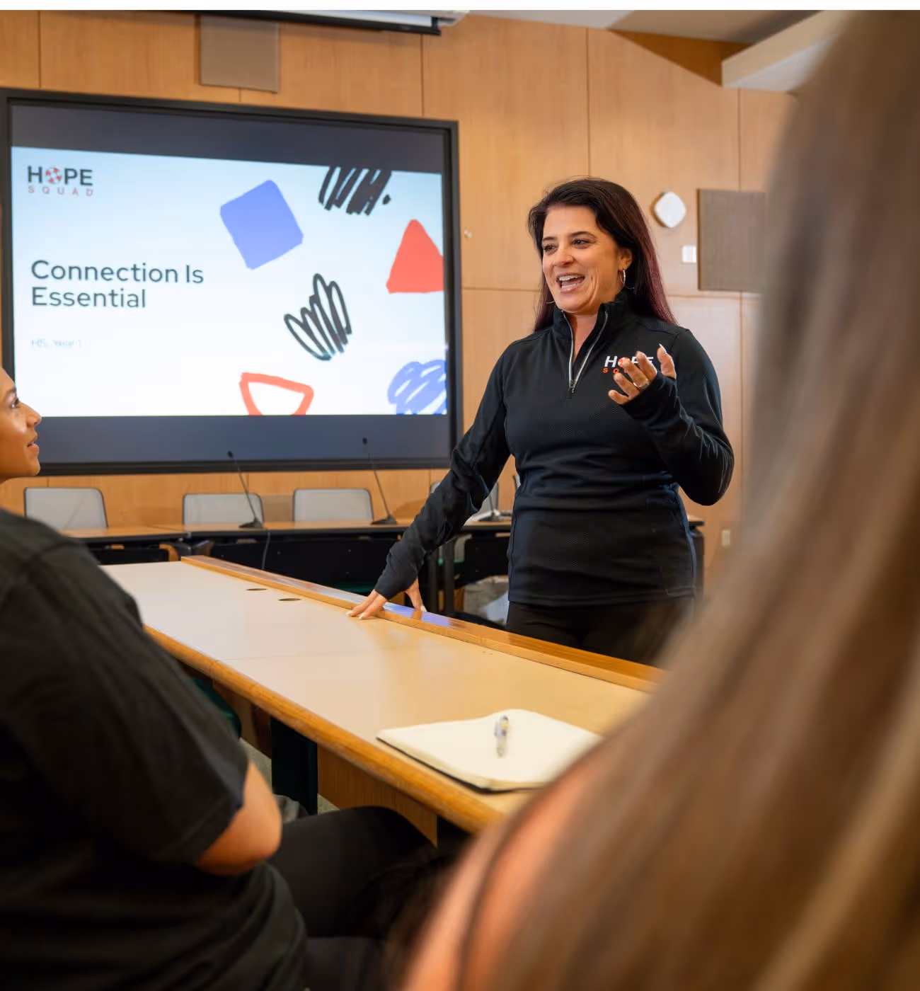 Woman standing in front a classroom of students and speaking.