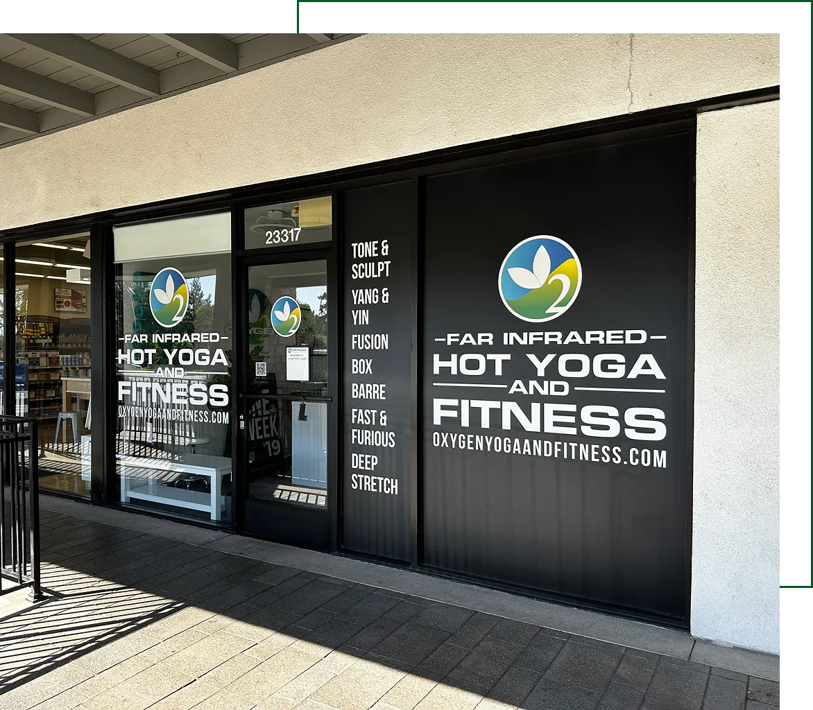 Storefront window signage for Hot Yoga and Fitness studio with logo and class offerings