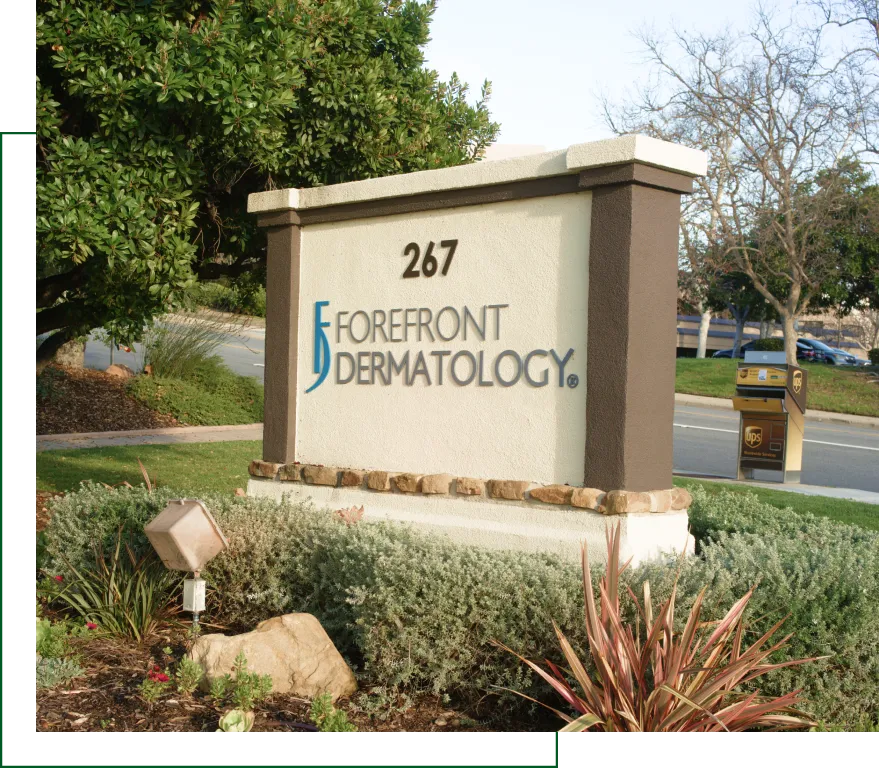 Freestanding entrance sign for Forefront Dermatology at 267, surrounded by landscaping and UPS drop boxes nearby