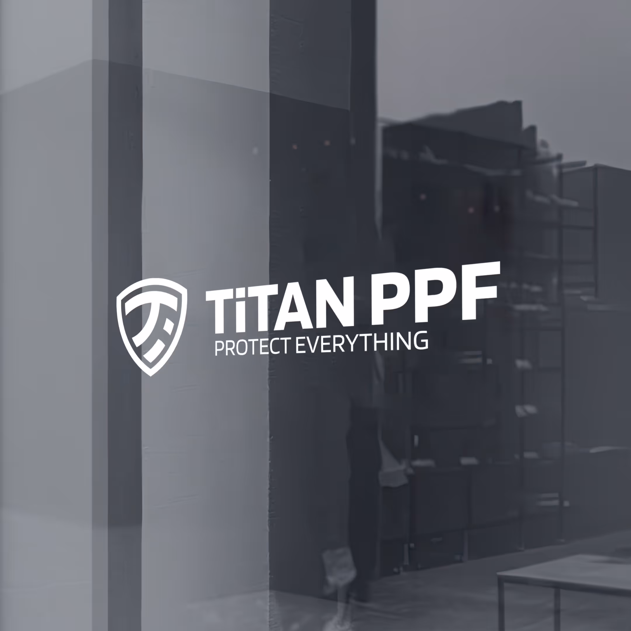 Logo Titan PPF z hasłem Protect Everything na szklanej powierzchni z odbiciem wnętrza.