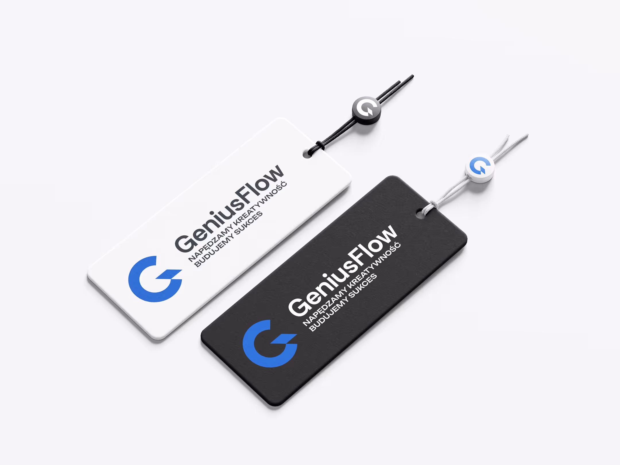 Dwie zawieszki z logo GeniusFlow, jedna biała z czarnym tekstem, druga czarna z białym tekstem i niebieskim symbolem.